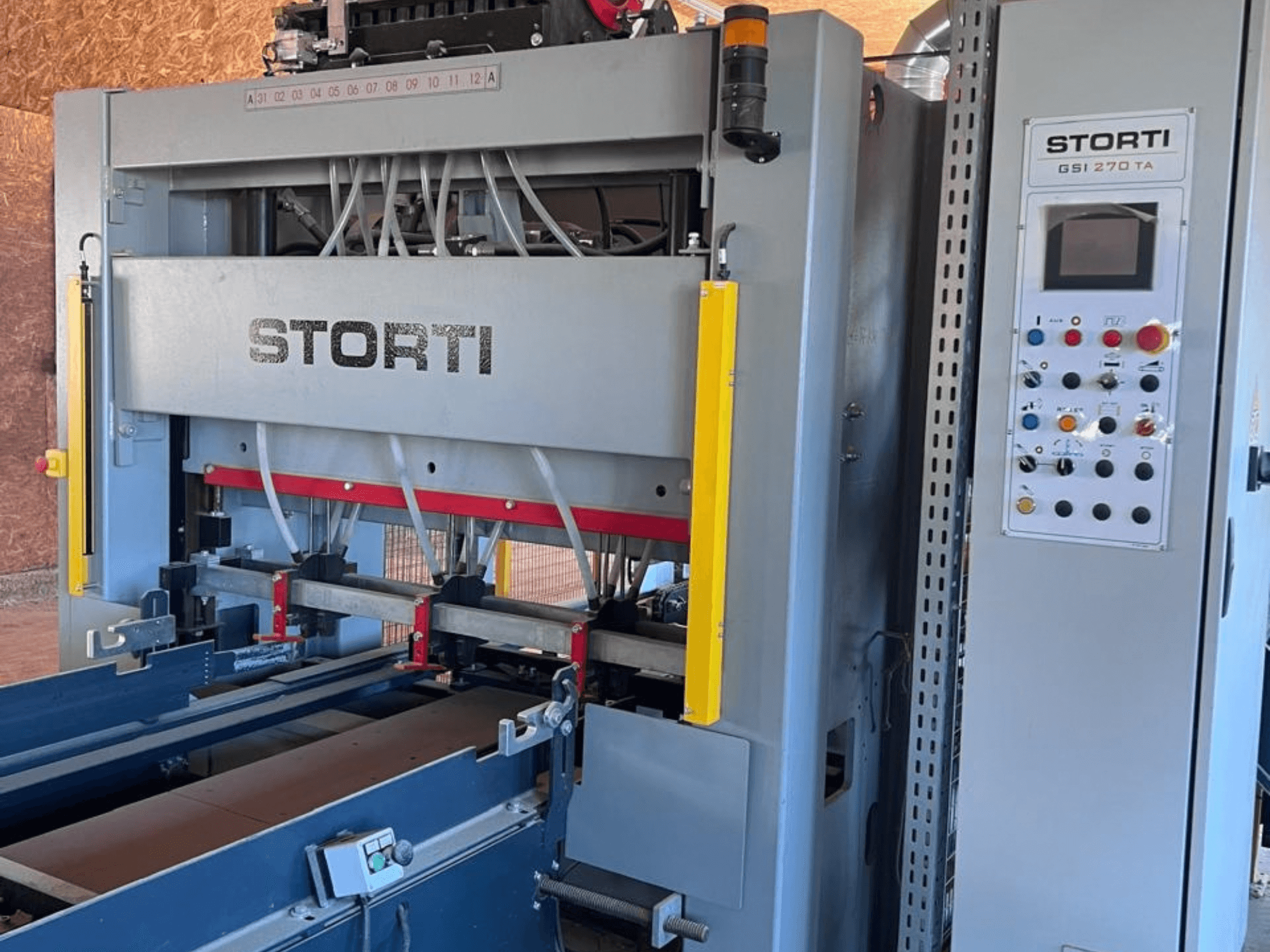 Линия по производству изделий из дерева STORTI GSI 170-270 TA9, вид спереди с панелью управления и механизмами гидравлического пресса.