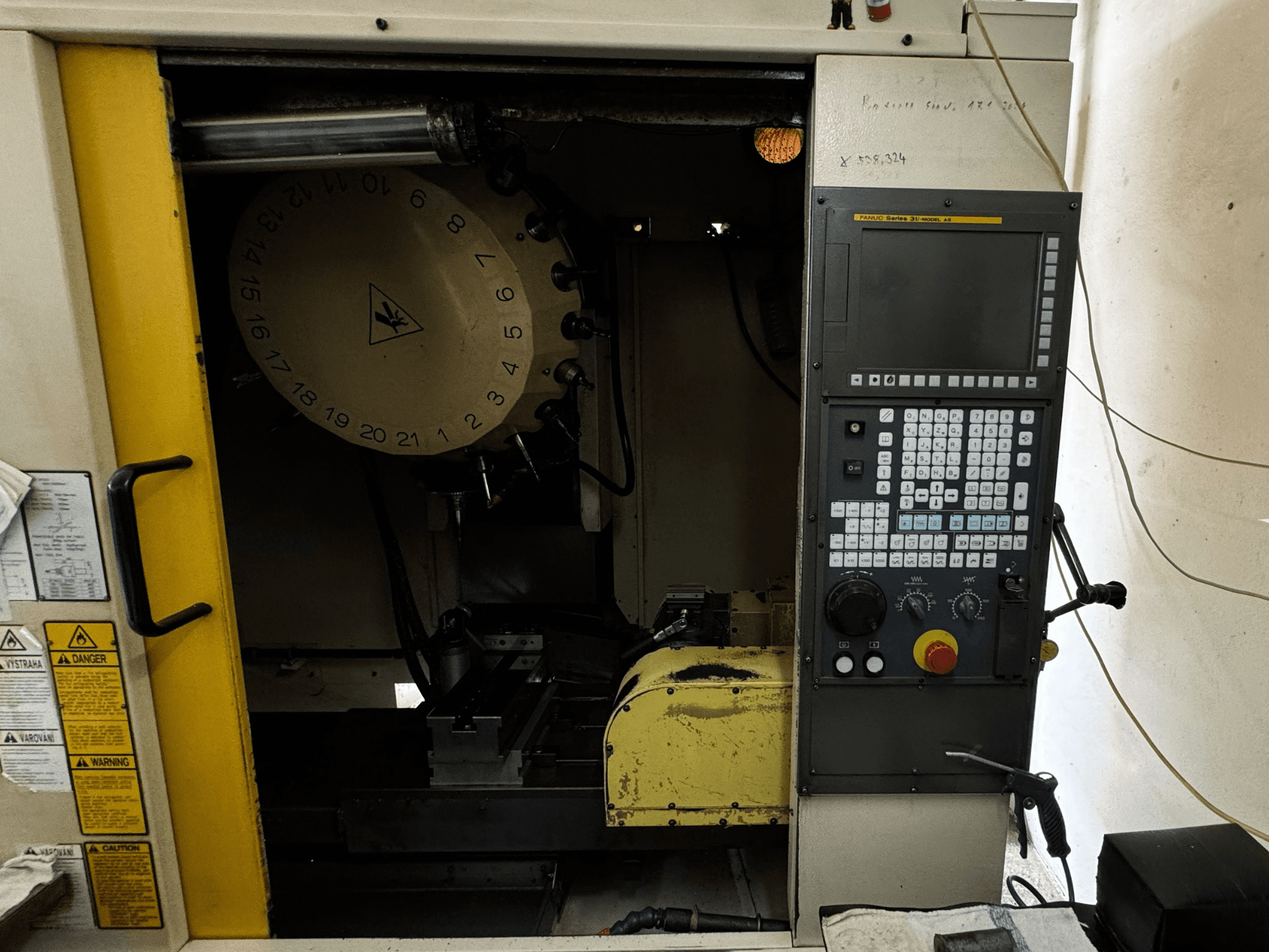 Вертикальный обрабатывающий центр FANUC Robodrill alpha-T21iFL, вид спереди, демонстрирующий панель управления и магазин инструментов.