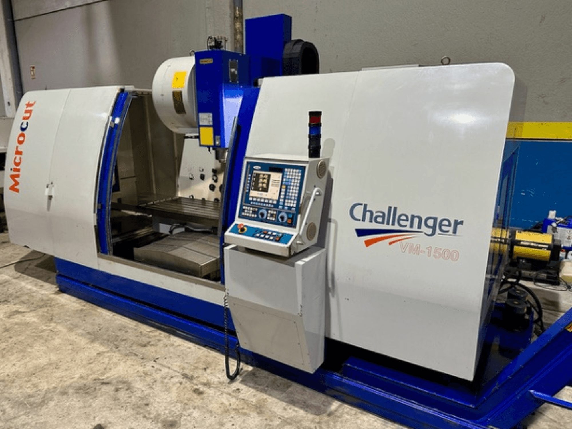 Станок с ЧПУ Microcut Challenger VM-1500, вид спереди, панель управления, рабочая область и синее основание.