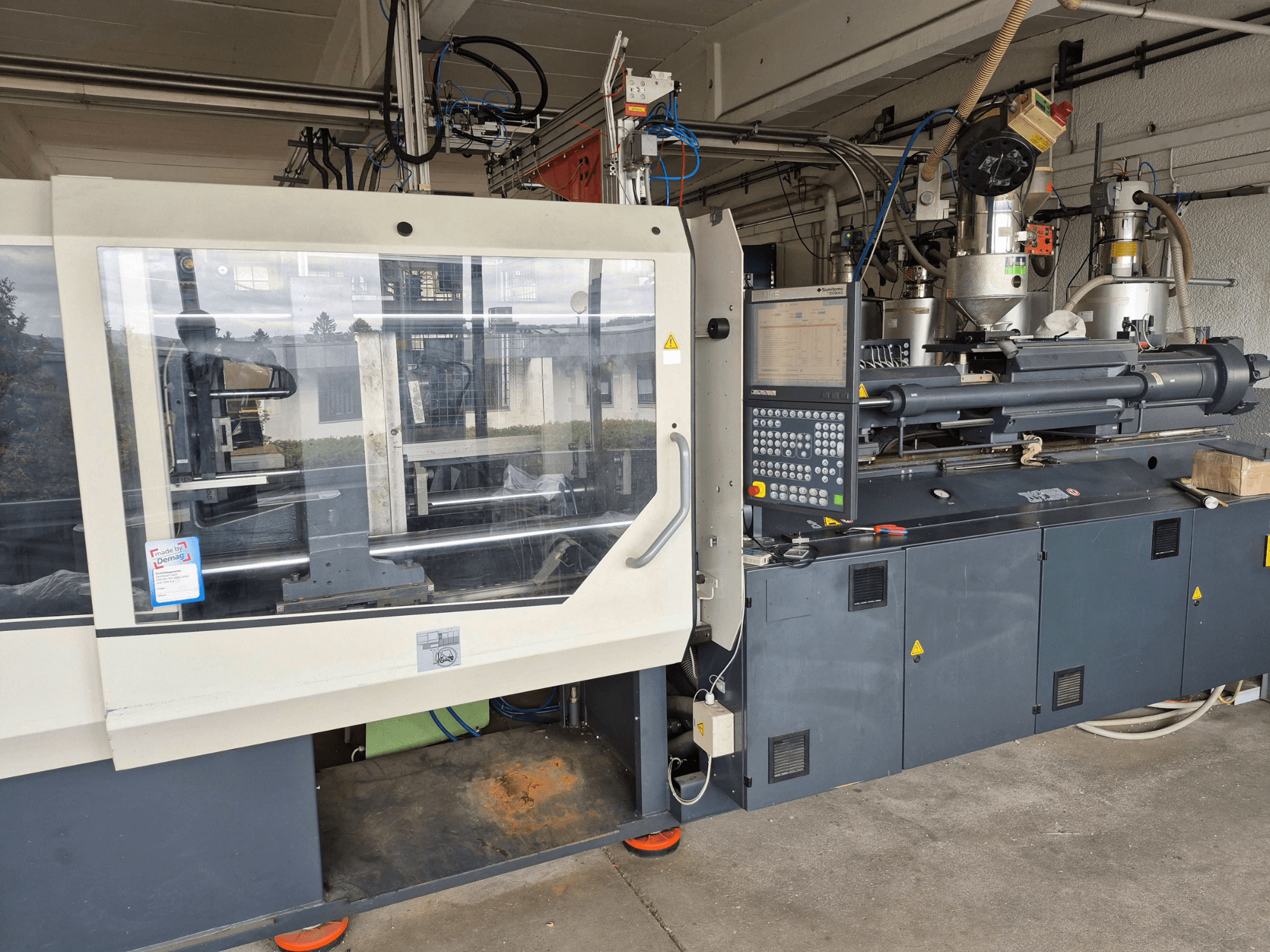 Гидравлическая машина для литья под давлением SUMITOMO SHI DEMAG Systec 210/580-1450, вид спереди с панелью управления и видимыми компонентами.