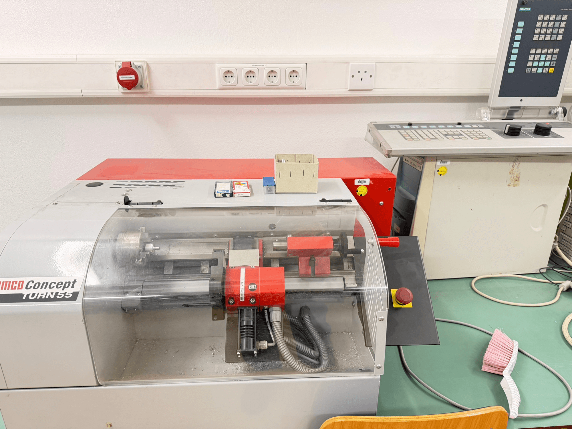Горизонтальный токарный станок EMCO Concept Turn 55 с красно-серым внешним видом, вид спереди, показывающий органы управления и рабочую зону.