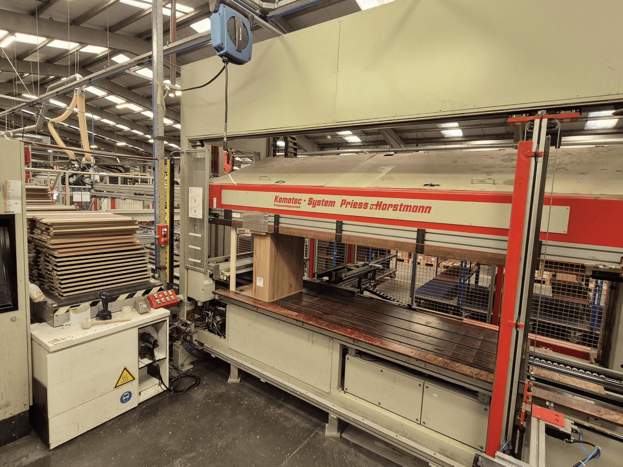 Шпоночный пресс KP-5-CNC производства PREISS U HORTSTMANN, вид спереди, демонстрирует уложенные листы шпона и панель управления.