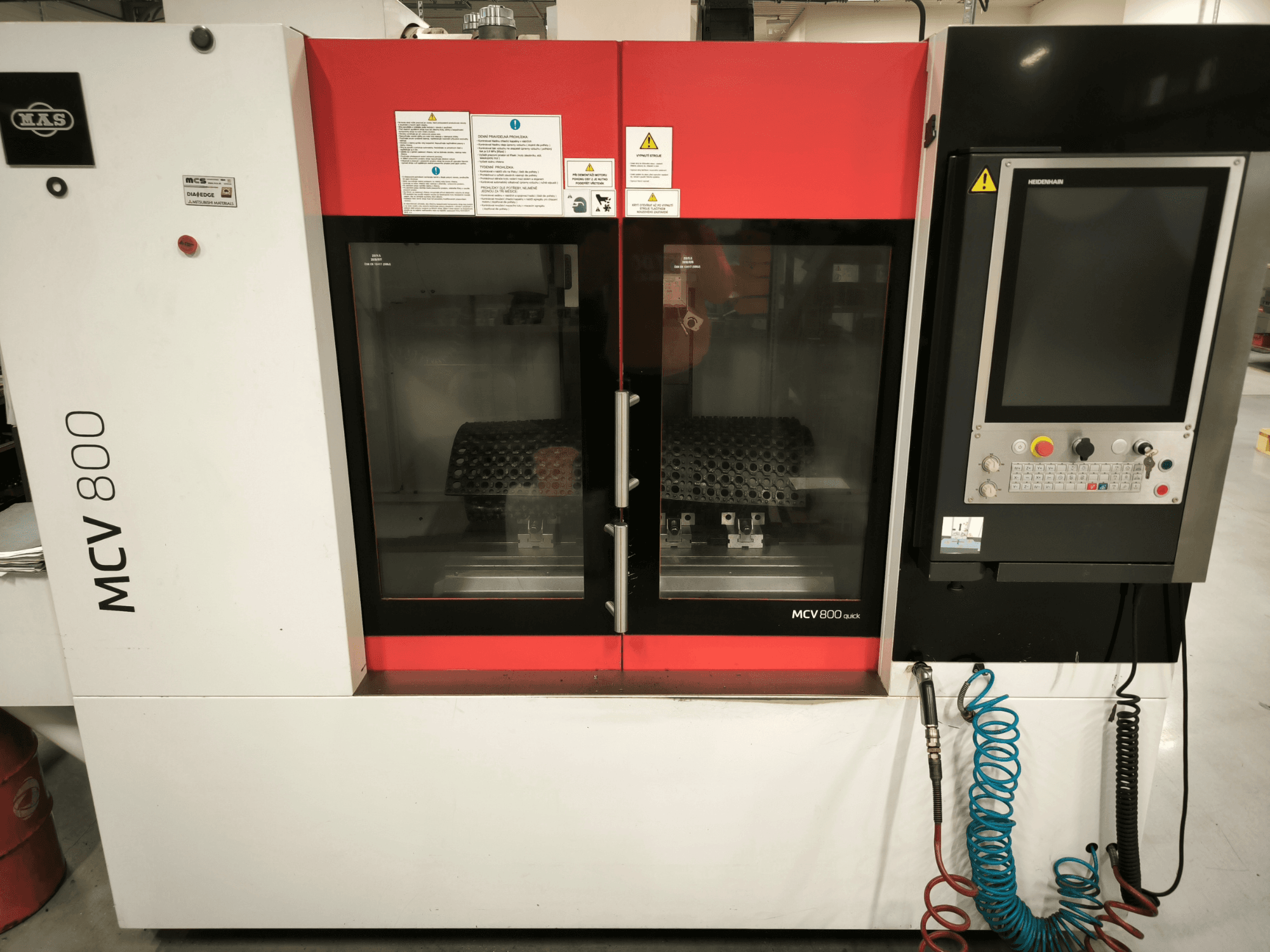 Вертикальный обрабатывающий центр KOVOSVIT MAS MCV 800 QUICK, вид спереди с панелью управления и двойными стеклянными дверями, демонстрирующими рабочее пространство.