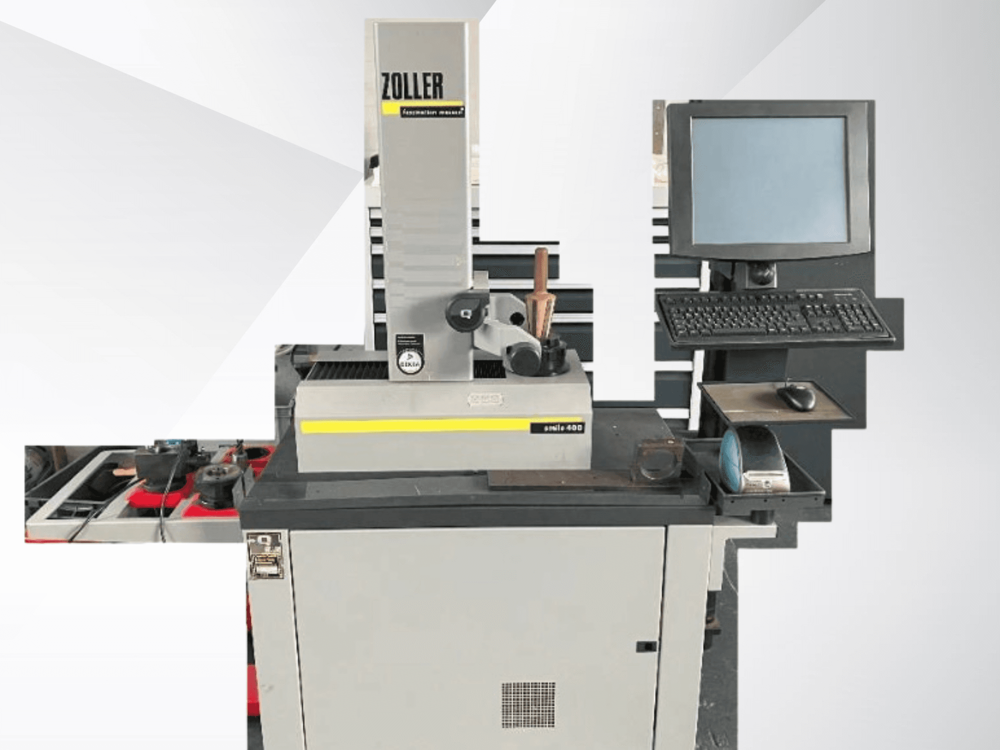 Измерительная машина ZOLLER с компьютерным монитором, клавиатурой и инструментами; вид спереди, серый цвет и современный дизайн.