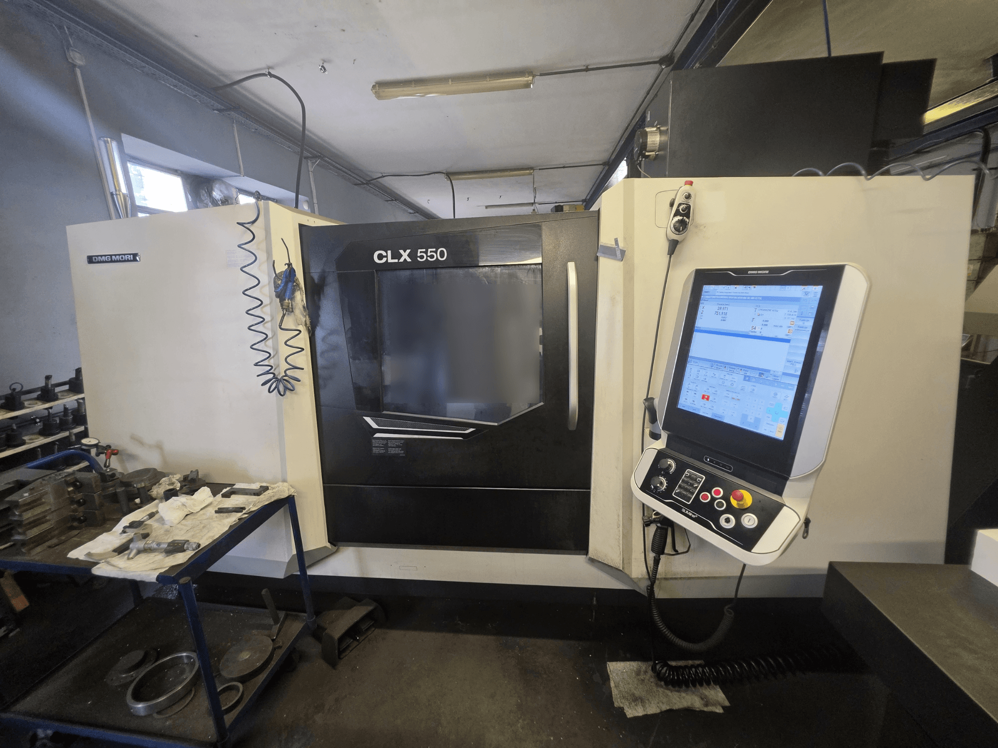 Горизонтальный токарный станок DMG MORI CLX 550 V3, вид спереди, на котором видны панель управления и рабочая зона с инструментами.