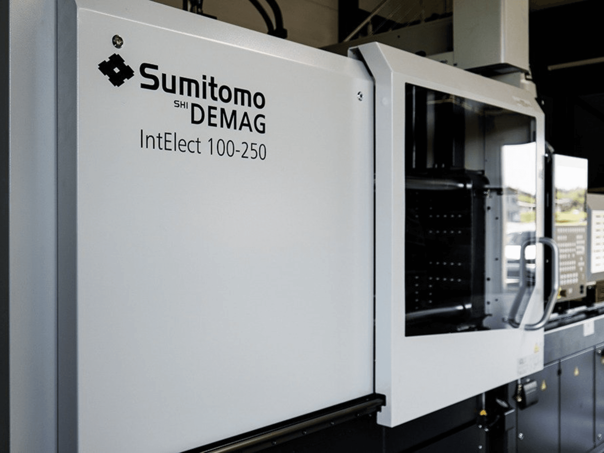 Вид спереди электрической термопластавтомата SUMITOMO SHI DEMAG IntElect 100/250 с панелью управления и средствами безопасности.