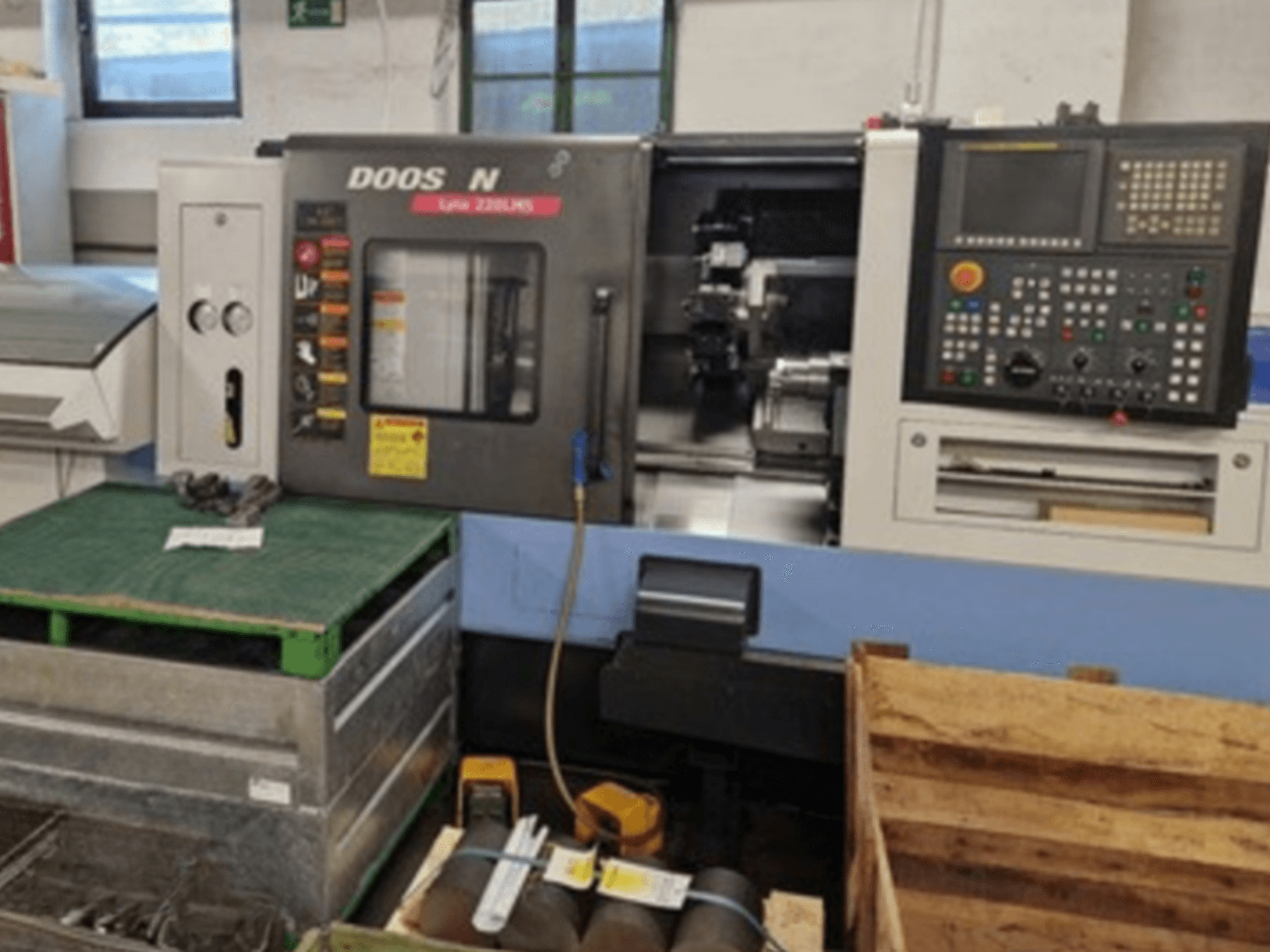 Горизонтальный токарный станок DOOSAN Lyax 220 LMS с видом спереди, демонстрирует панель управления, инструменты и рабочую зону.