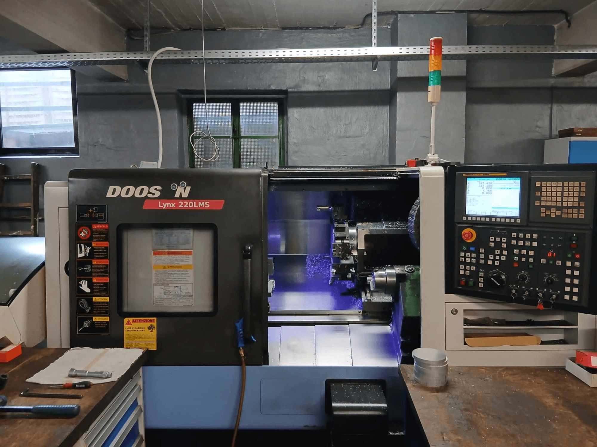Горизонтальный токарный станок DOOSAN Lynx 220 LMS, вид спереди, с панелью управления и видимой зоной обработки.