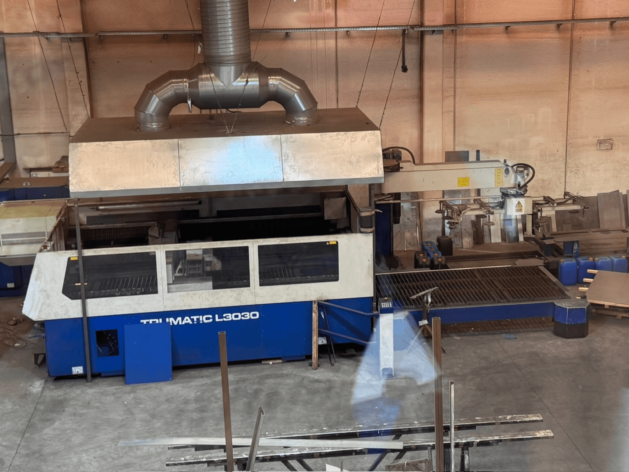 Лазерный резак CO2 TRUMPF TRUMATIC L3030 в цехе, вид спереди с панелью управления и режущим столом.