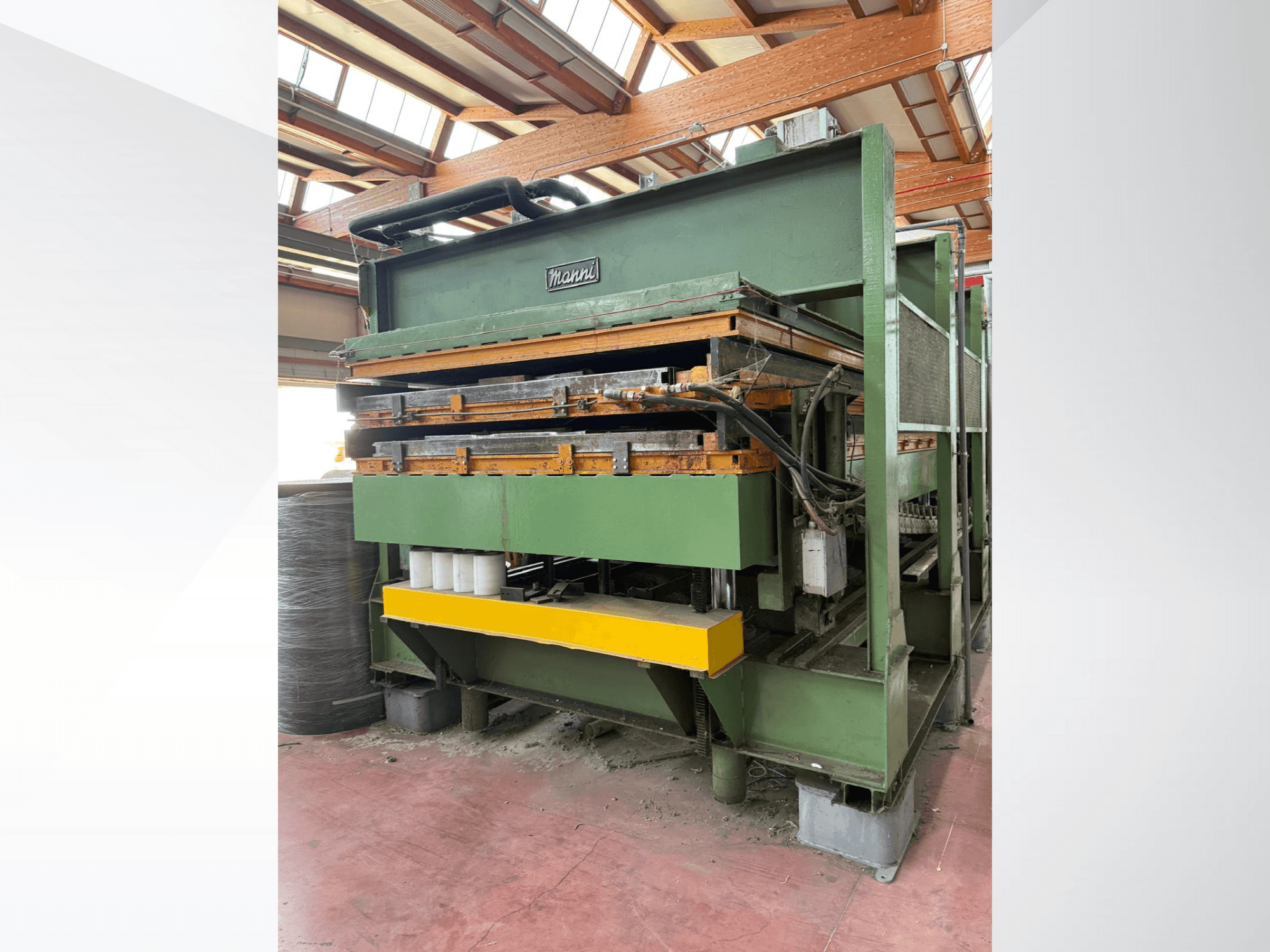 Гидравлический пресс Manni, вид сбоку, корпус из зеленого металла, желтое основание, видны многочисленные гидравлические линии.
