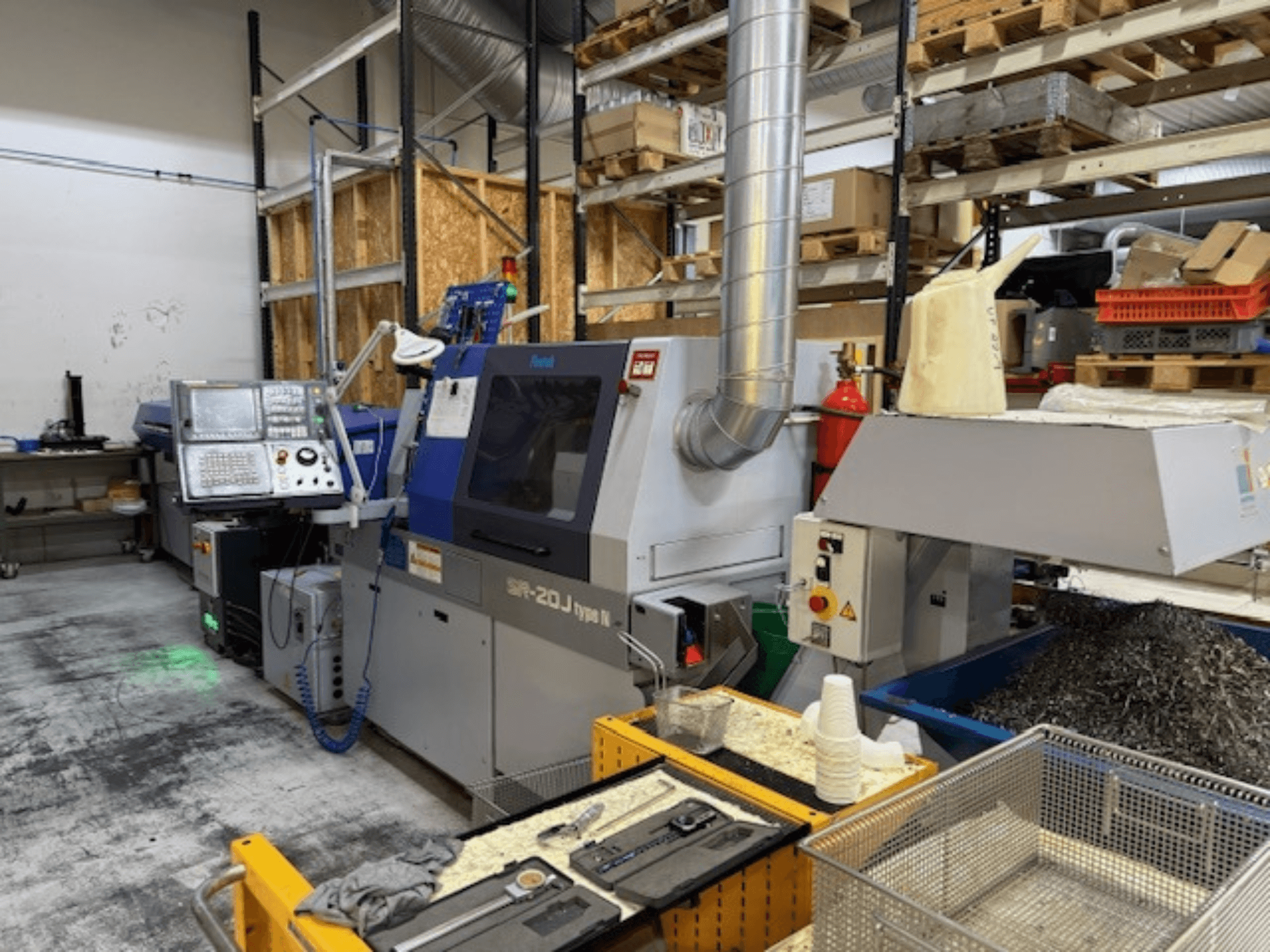 Вид спереди на обрабатывающий центр Faroh SPR-20J типа N с панелью управления, металлической стружкой и защитным оборудованием в мастерской.