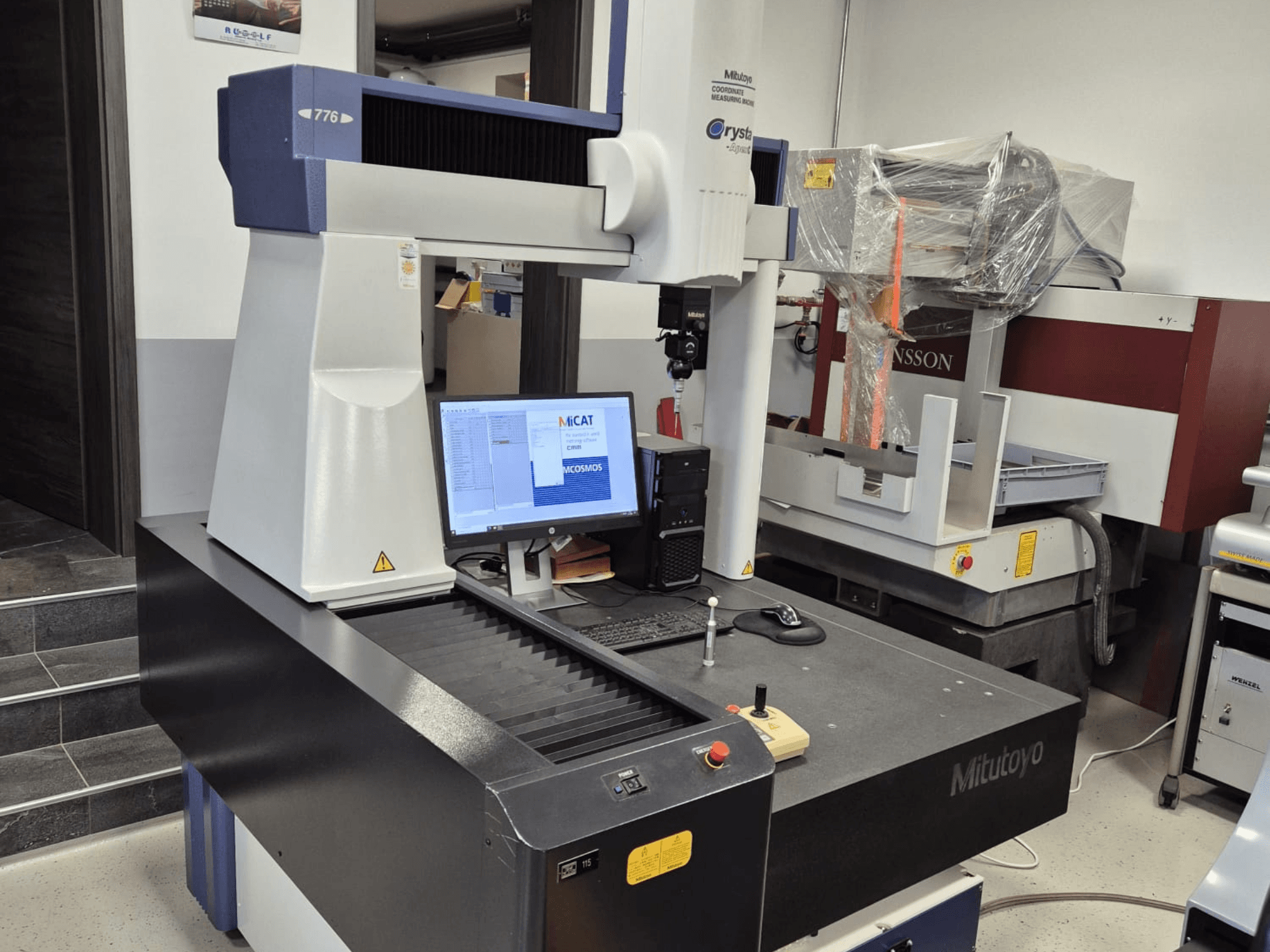 Координатно-измерительная машина Mitutoyo модели 776 на переднем плане, на мониторе отображается программное обеспечение для измерений, видны элементы управления.