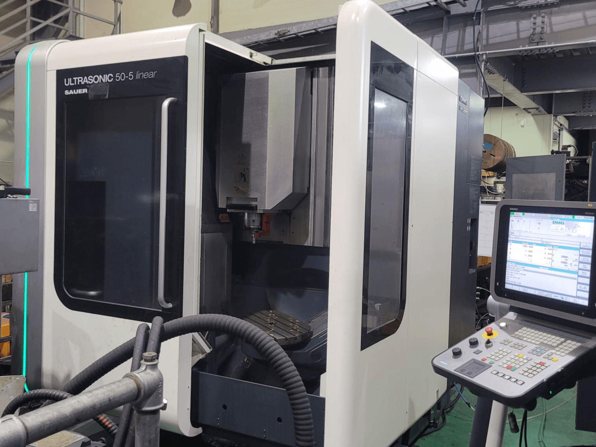Линейный универсальный обрабатывающий центр DMG ULTRASONIC 50-5, вид спереди с панелью управления и видимой рабочей зоной.