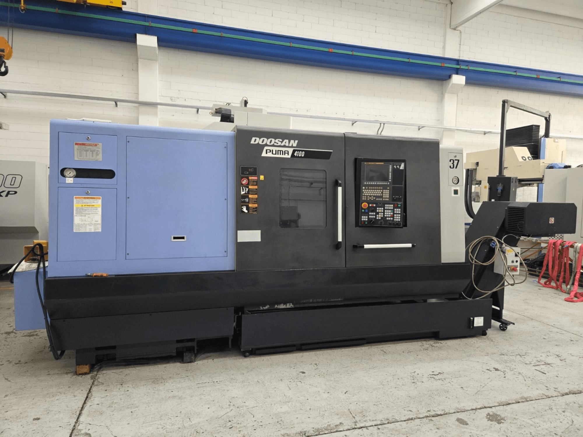 Токарный станок с ЧПУ Doosan Puma 4100, вид спереди; панель управления, синяя силовая установка и подробные надписи для руководства по эксплуатации.