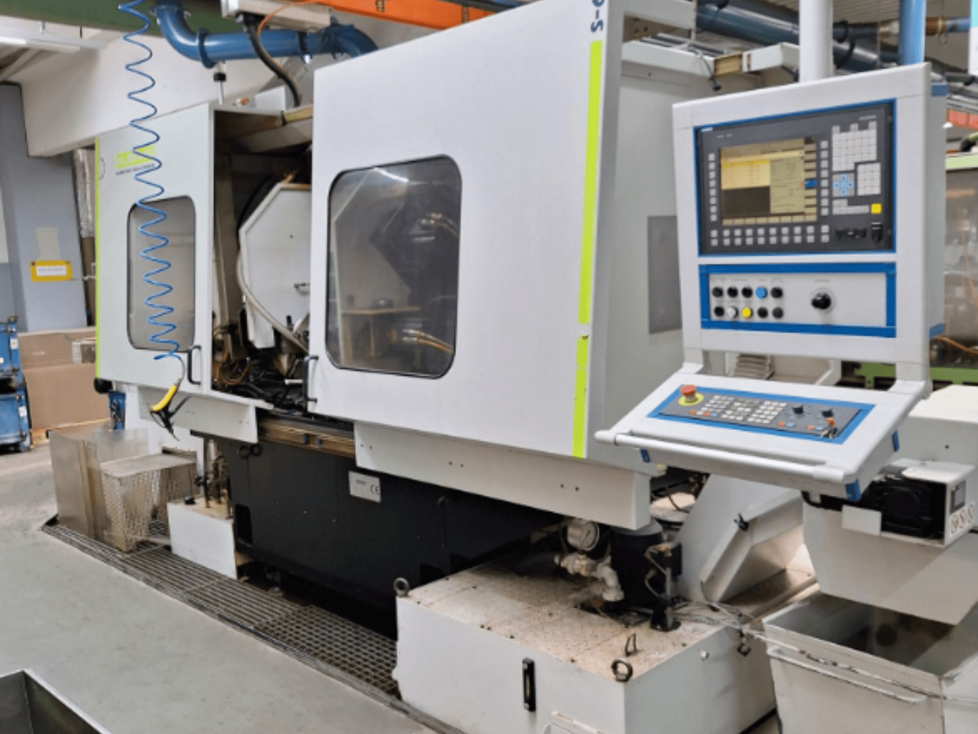 Промышленный фрезерный станок с панелью управления, вид сбоку, с двумя камерами и видимыми соединениями трубопроводов.