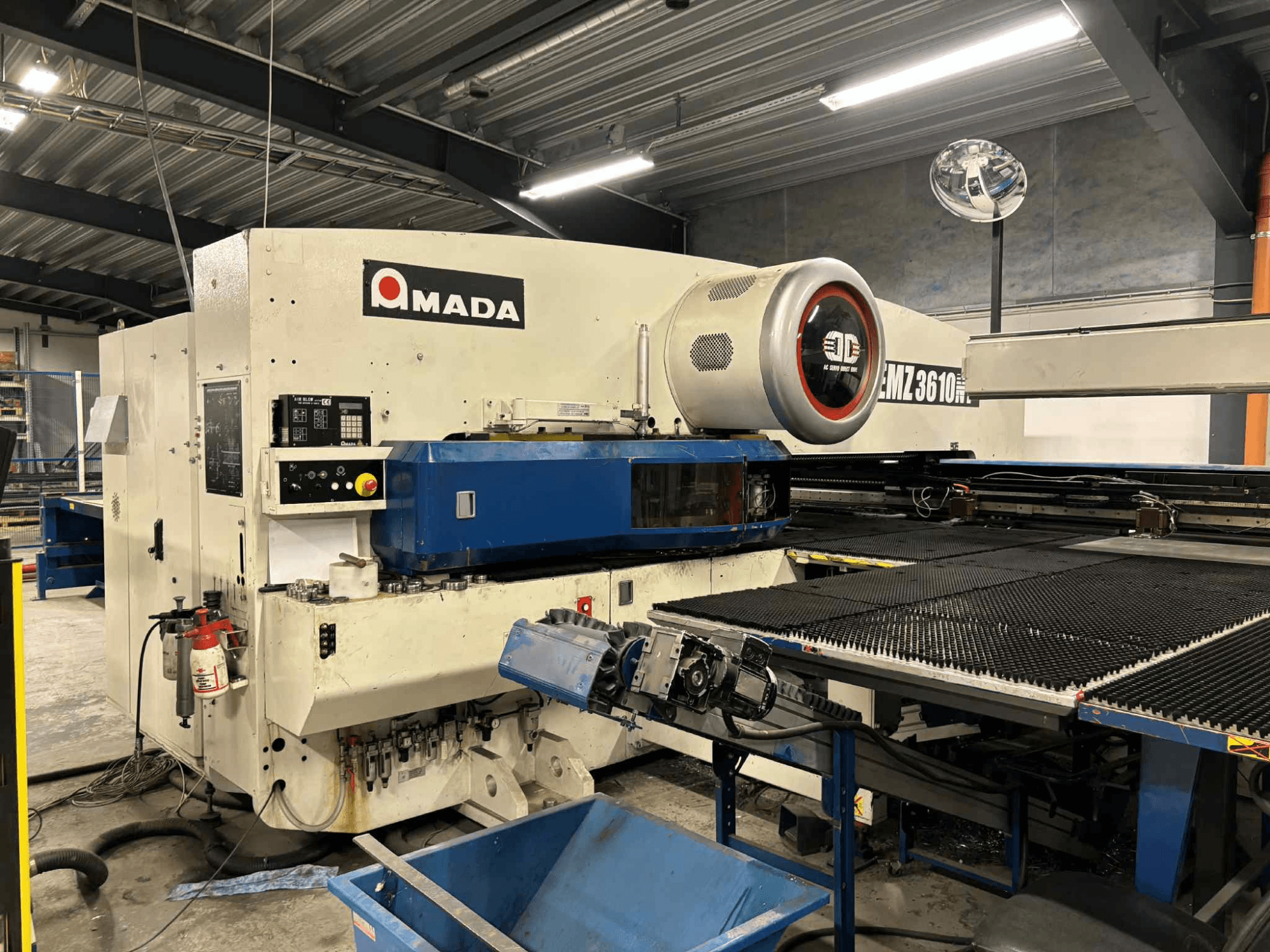 Пробивной пресс Amada EMZ3610H спереди; элементы управления, синяя станина и защитное оборудование.