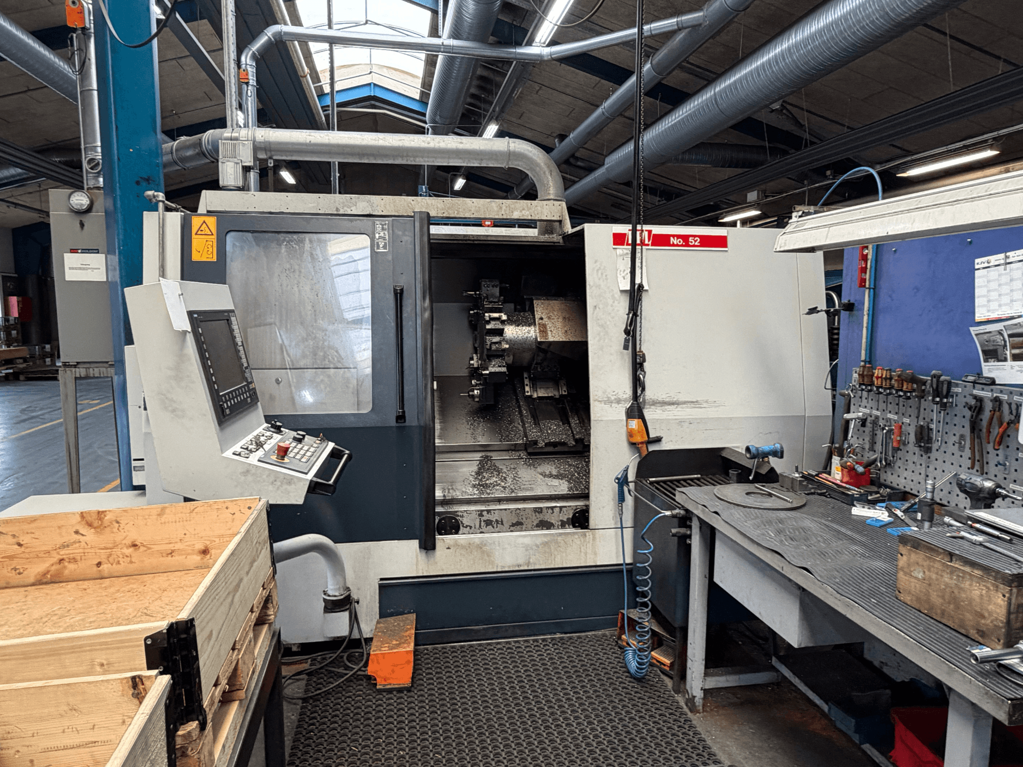 Горизонтальный токарный станок SPINNER TC800 110 SMCY, вид спереди, с панелью управления и соседней рабочей зоной.