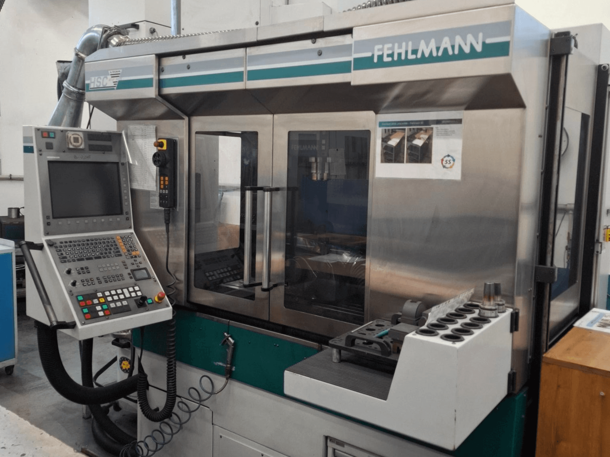 Станок с ЧПУ Fehlmann HSC 20, вид спереди, панель управления, металлический корпус и держатель инструмента с несколькими пазами.