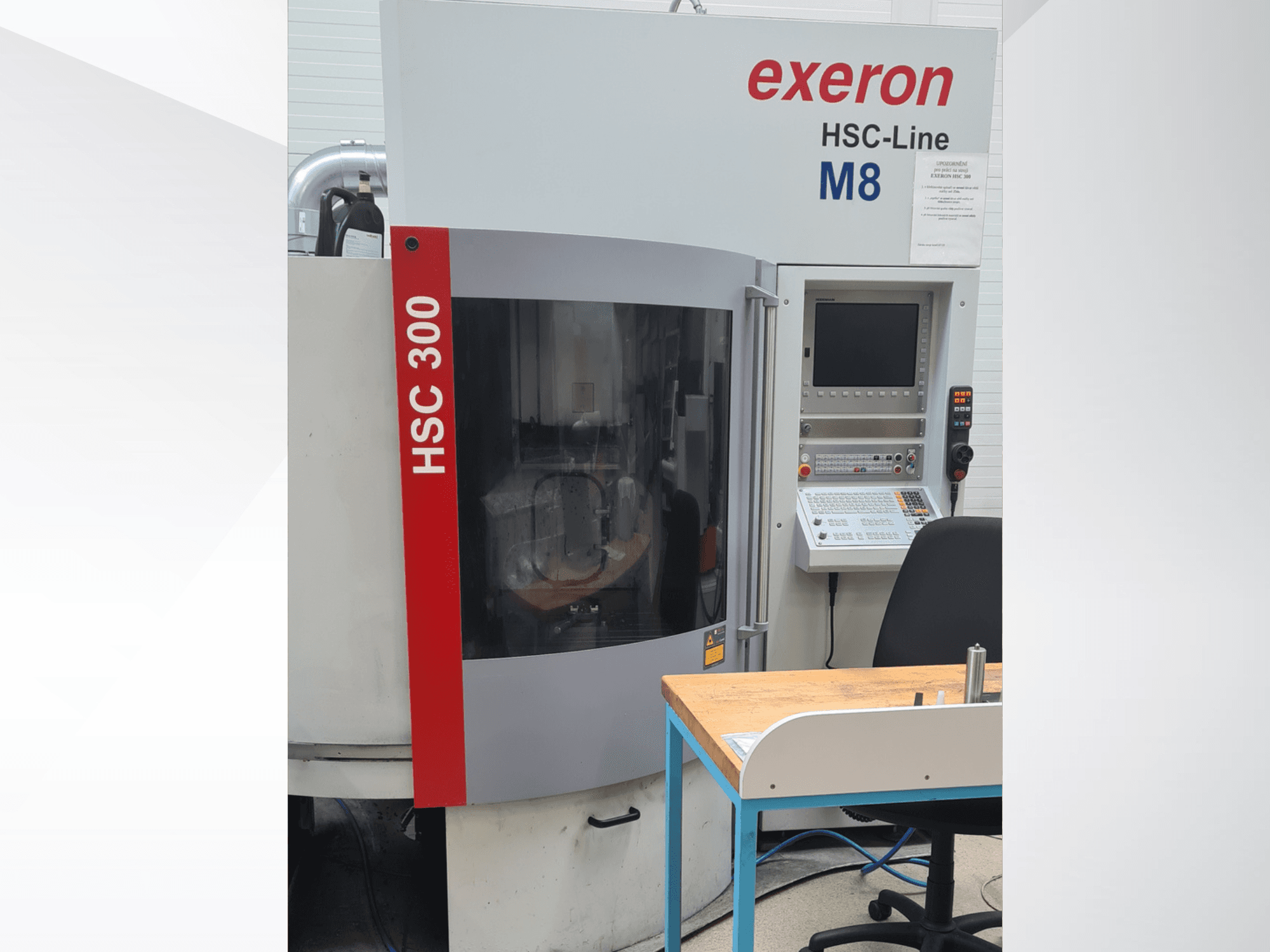 Вертикальный обрабатывающий центр Exeron HSC 300/3, вид спереди, на котором видны панель управления и рабочий стол.