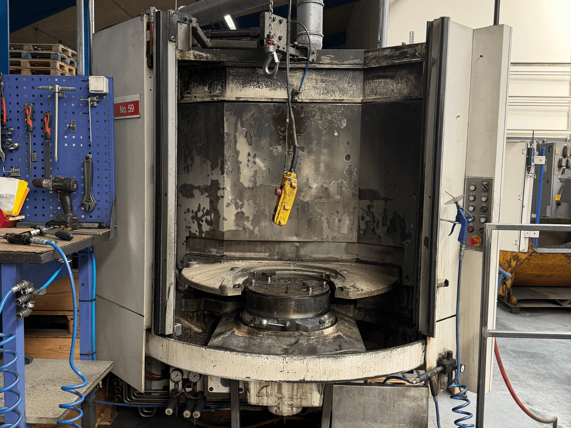 Горизонтальный обрабатывающий центр HELLER MC 16 вид спереди, демонстрирующий пустой рабочий стол и панель управления, в условиях мастерской.