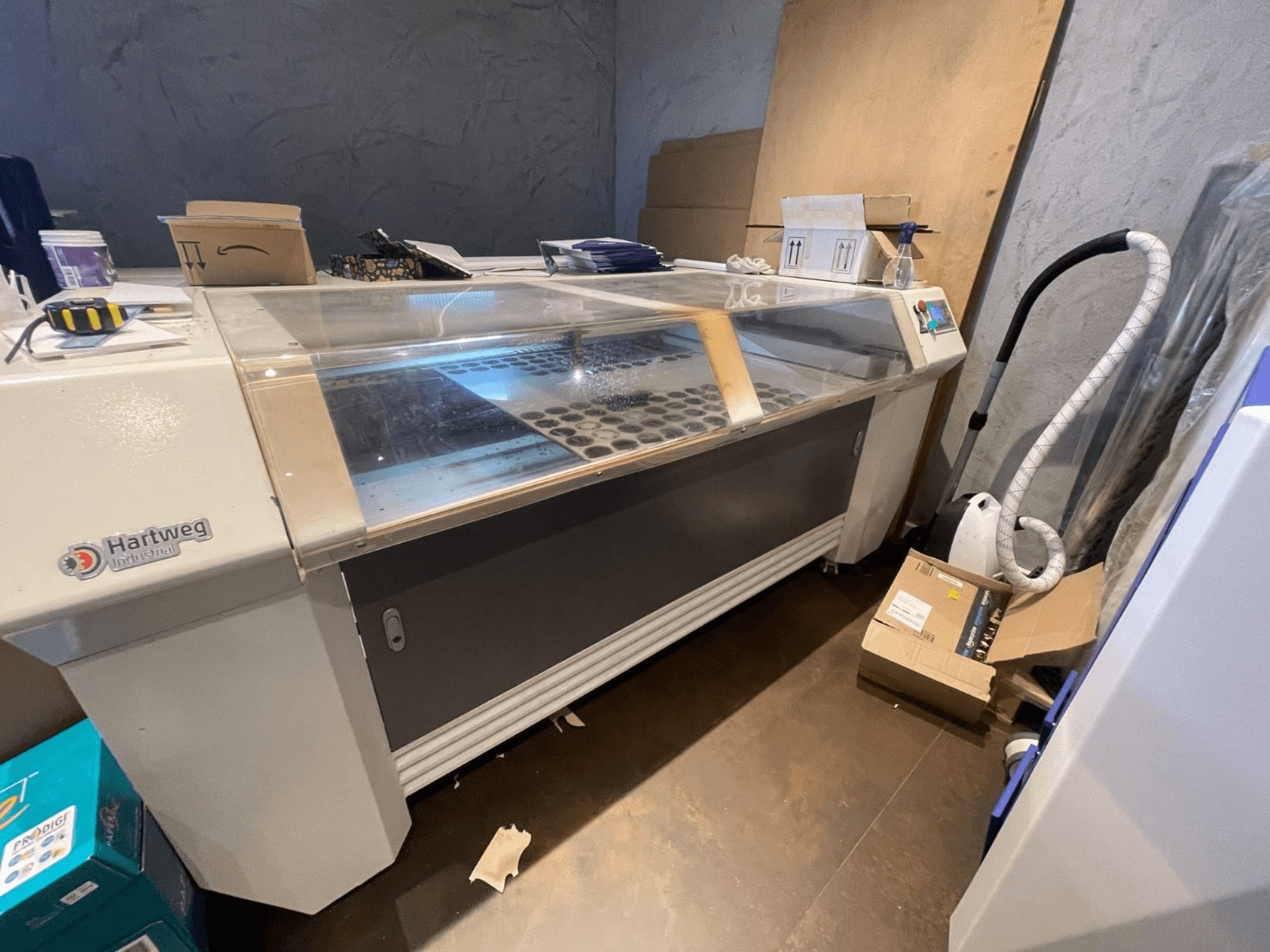 Станок лазерной резки CO2 Bodor CL-1610XUF вид сбоку, демонстрирующий рабочую зону со слотами для материалов и панель управления.