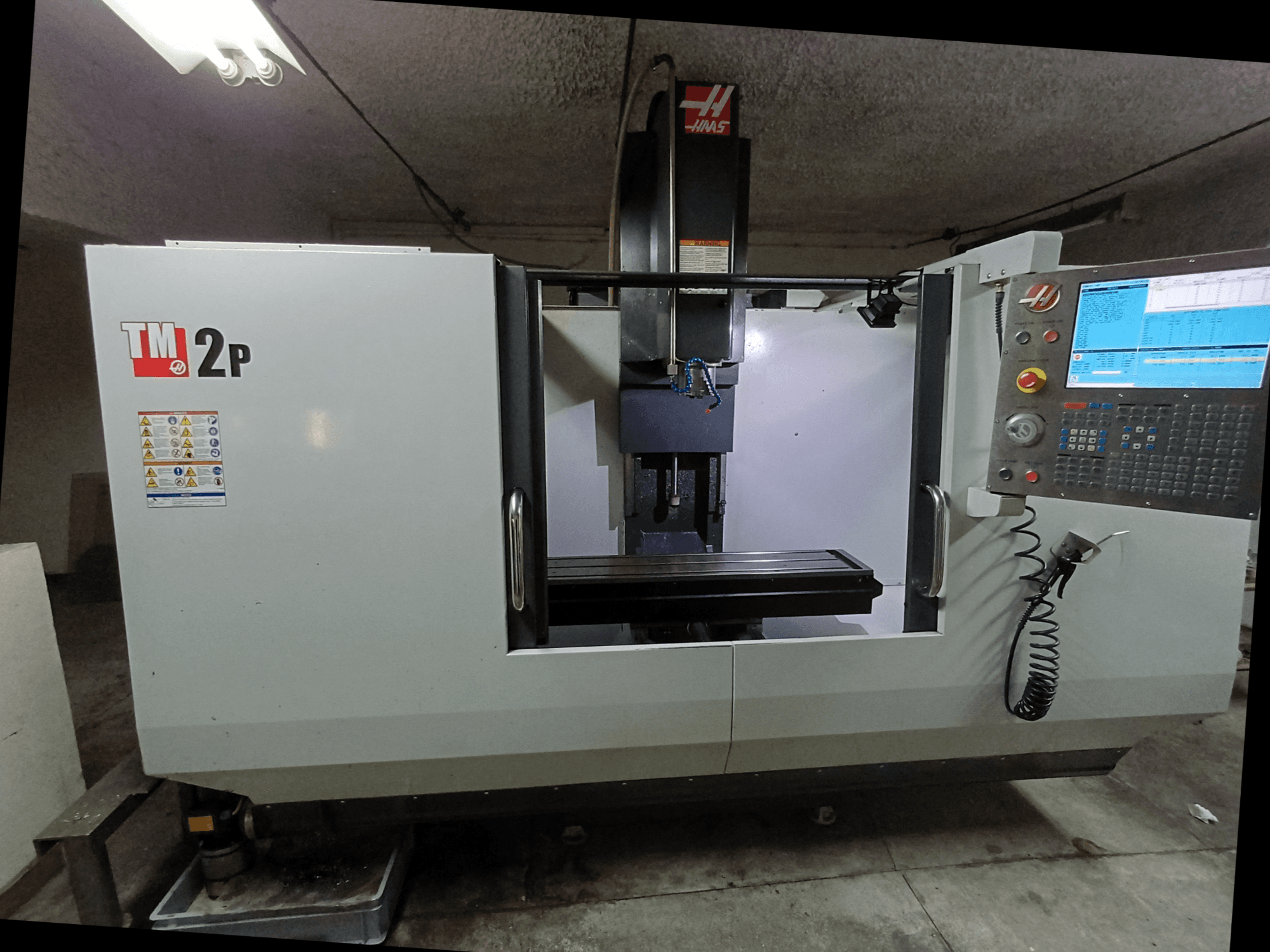 Вертикальный обрабатывающий центр HAAS TM-2P, вид спереди, панель управления, шпиндельная бабка и станина станка.