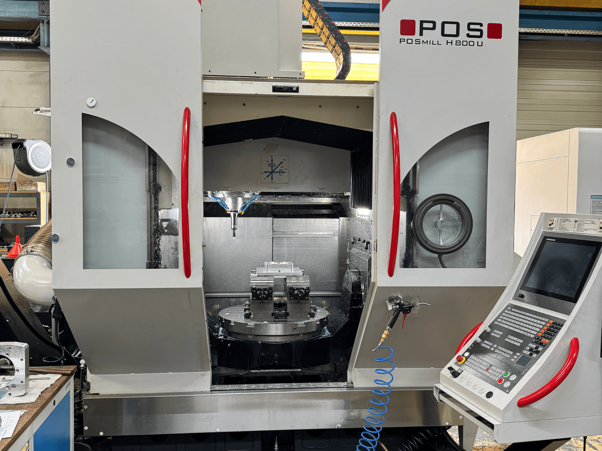 Вертикальный обрабатывающий центр POSmill H 800 U, вид спереди, на котором видны внутренние компоненты, система охлаждения и панель управления.