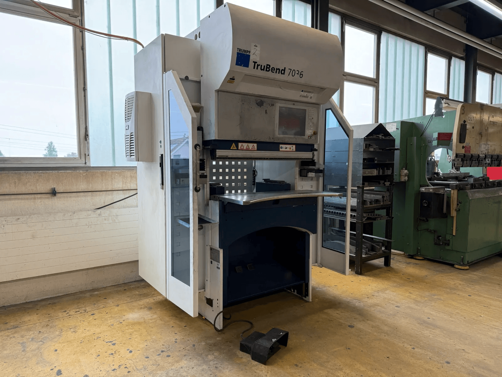 Гибочный пресс TRUMPF TruBend 7036 в цехе, вид спереди с открытой дверью, на котором видны панель управления и зона гибки.