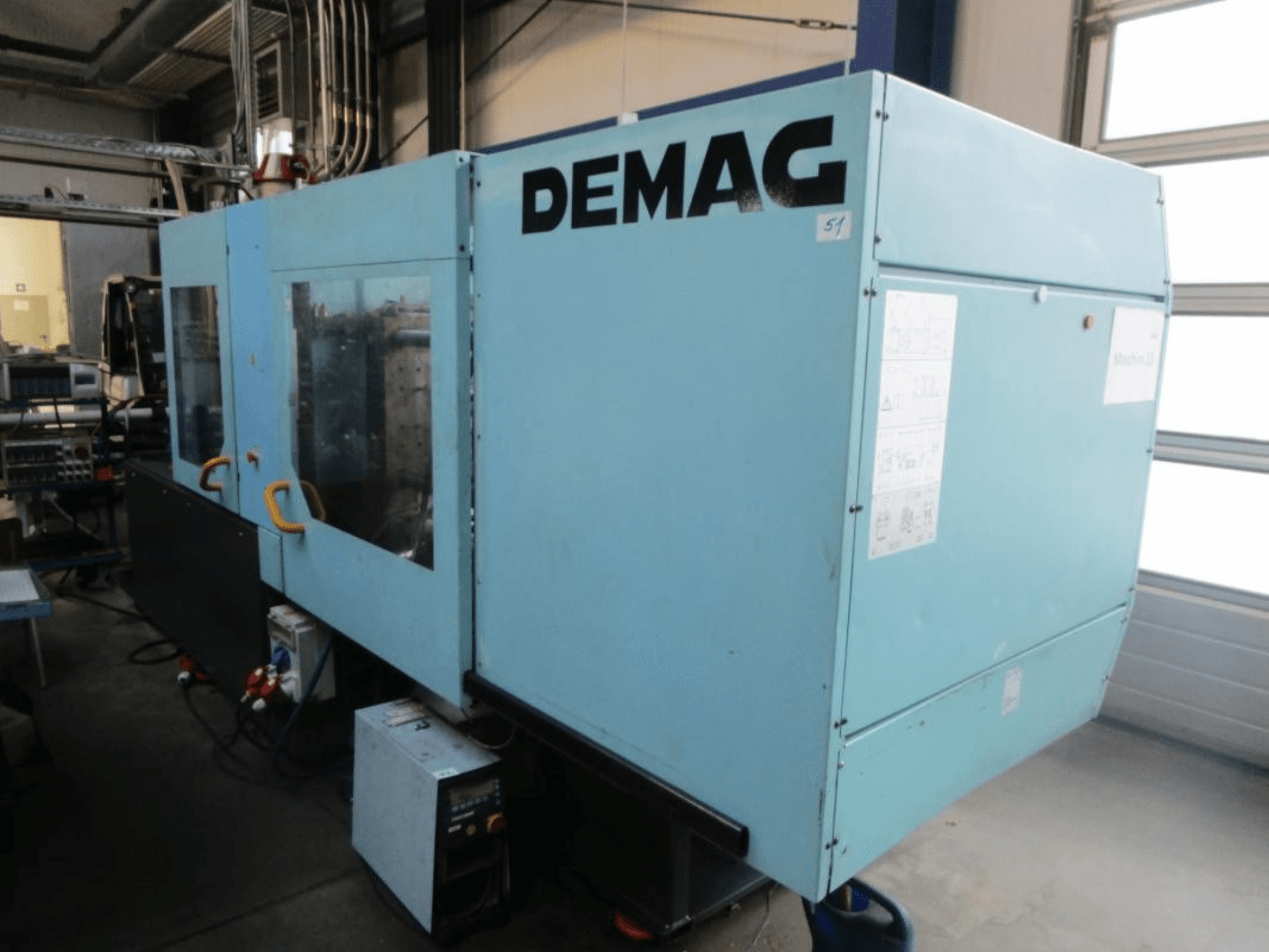 Вид спереди гидравлического термопластавтомата DEMAG Ergotech 150-610 Viva с хорошо различимой панелью управления и ручками.