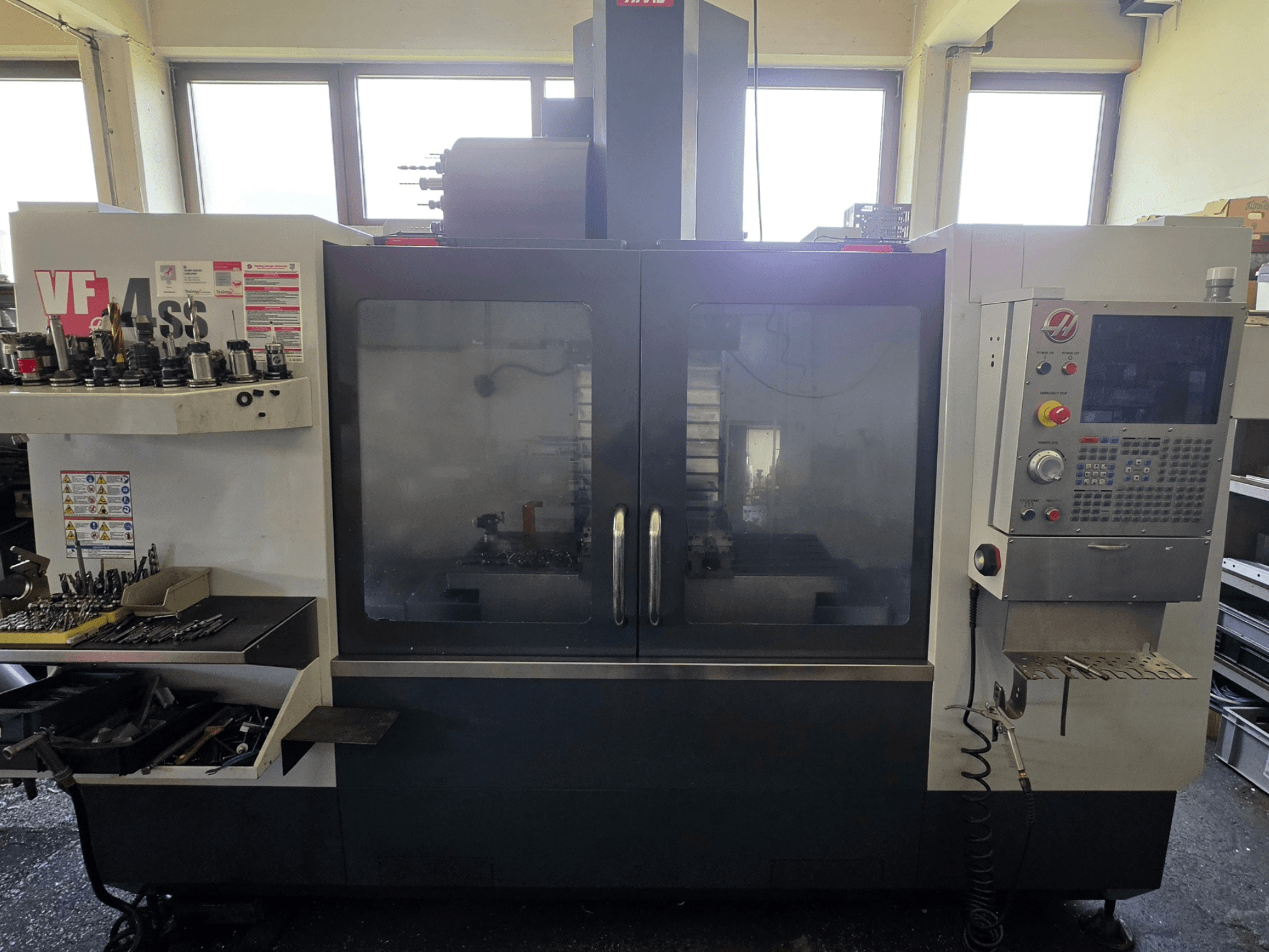 Вертикальный обрабатывающий центр HAAS VF 34SS вид спереди, демонстрирует панель управления и зону хранения инструментов.