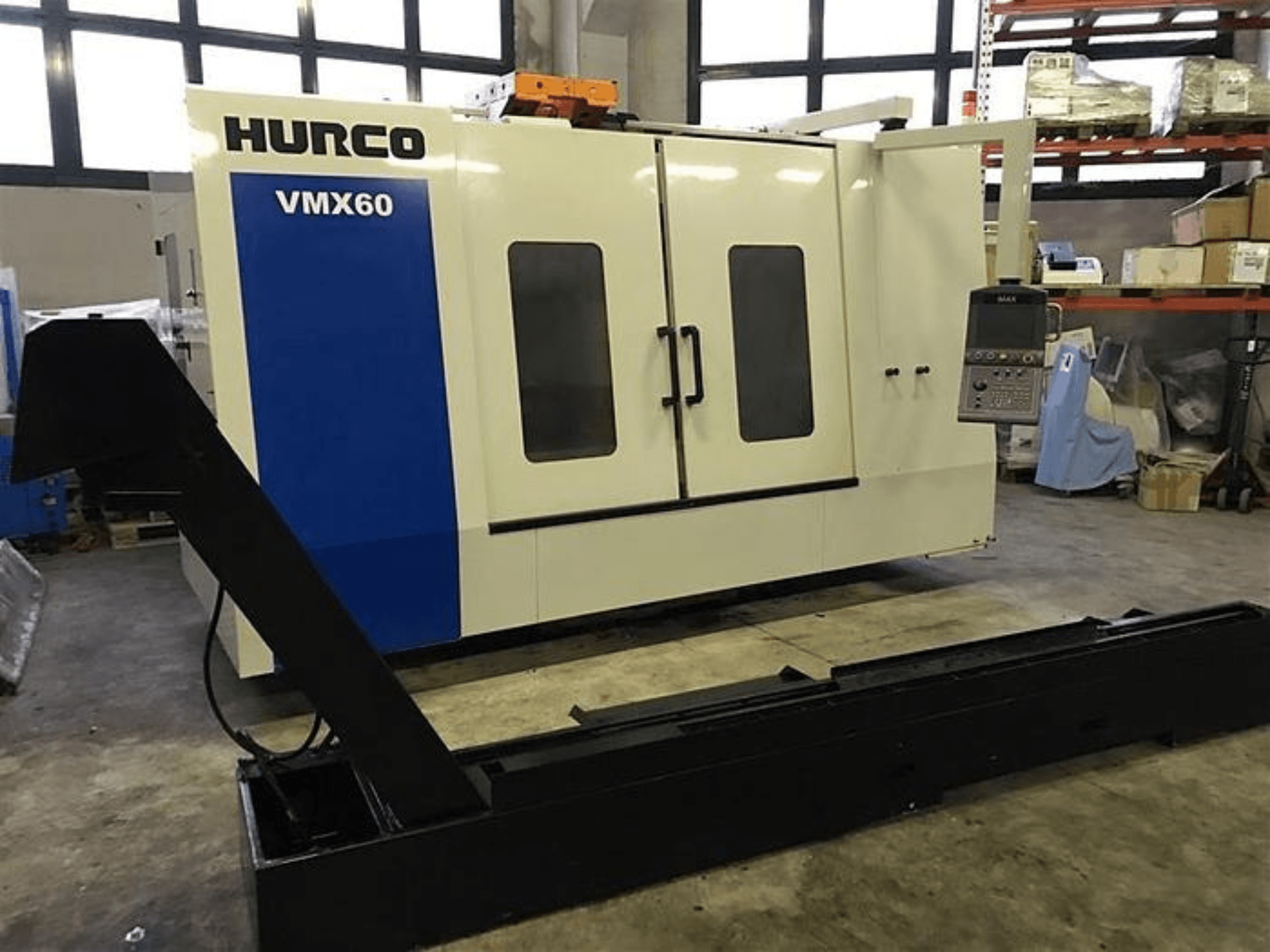 Станок с ЧПУ HURCO VMX60 в мастерской, вид спереди, с панелью управления и прикрепленной черной несущей шиной.