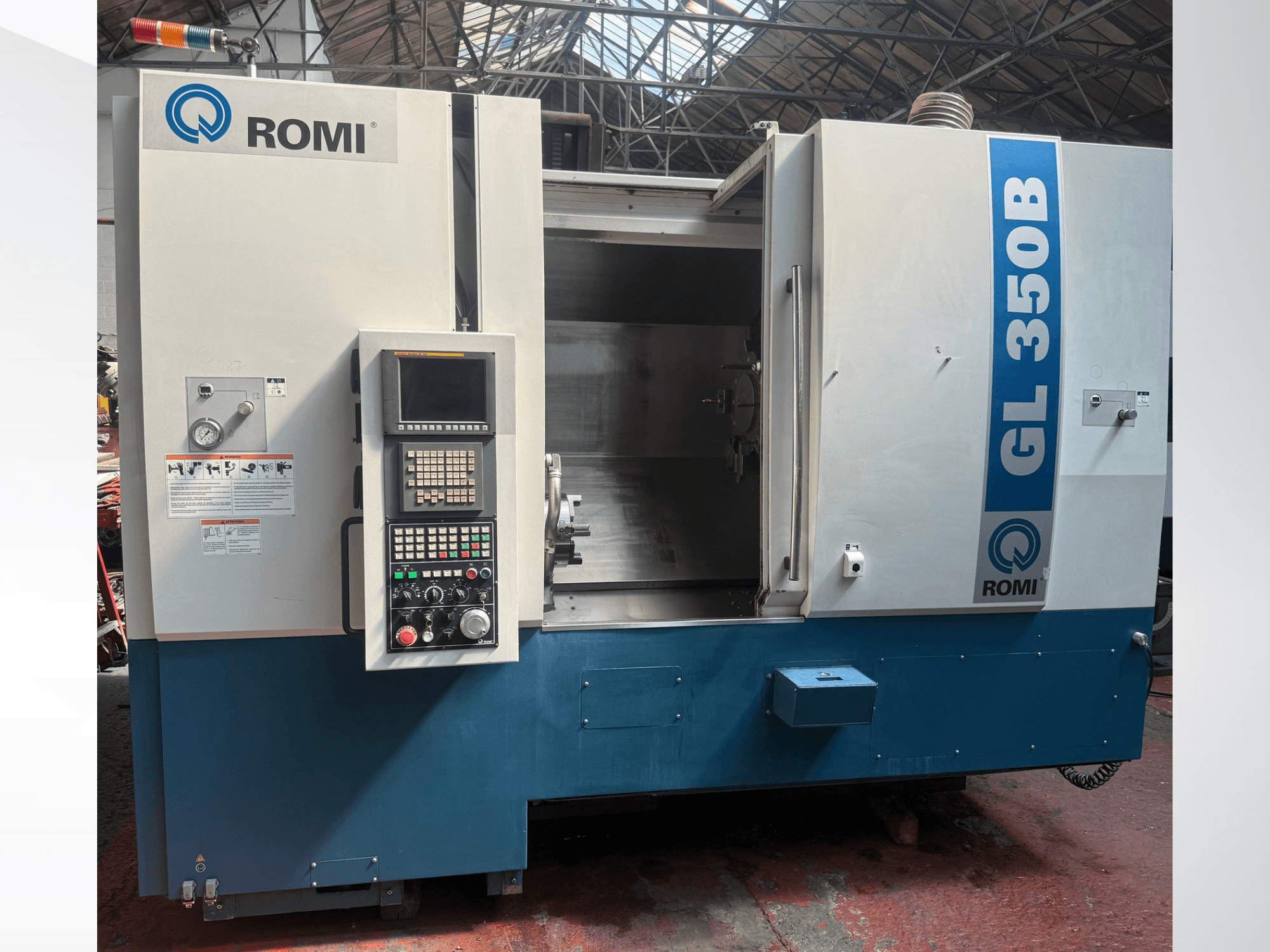 Вид спереди на горизонтальный токарный станок Romi GL 350B, демонстрирующий панель управления и открытую рабочую зону.