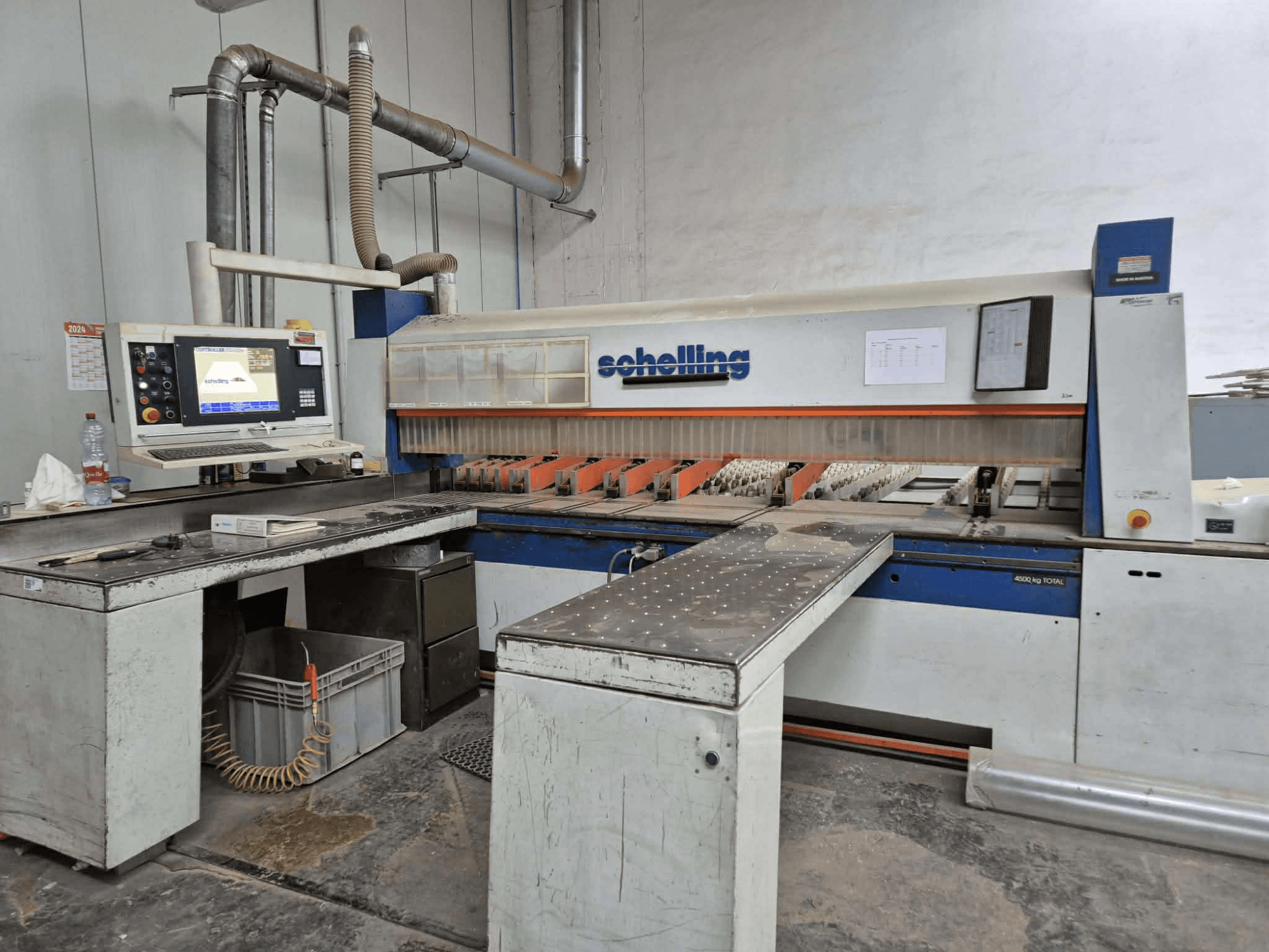 Машинка для резки Schaublin с видом сбоку, с компьютерным интерфейсом, острыми лезвиями и прочной металлической рабочей поверхностью.