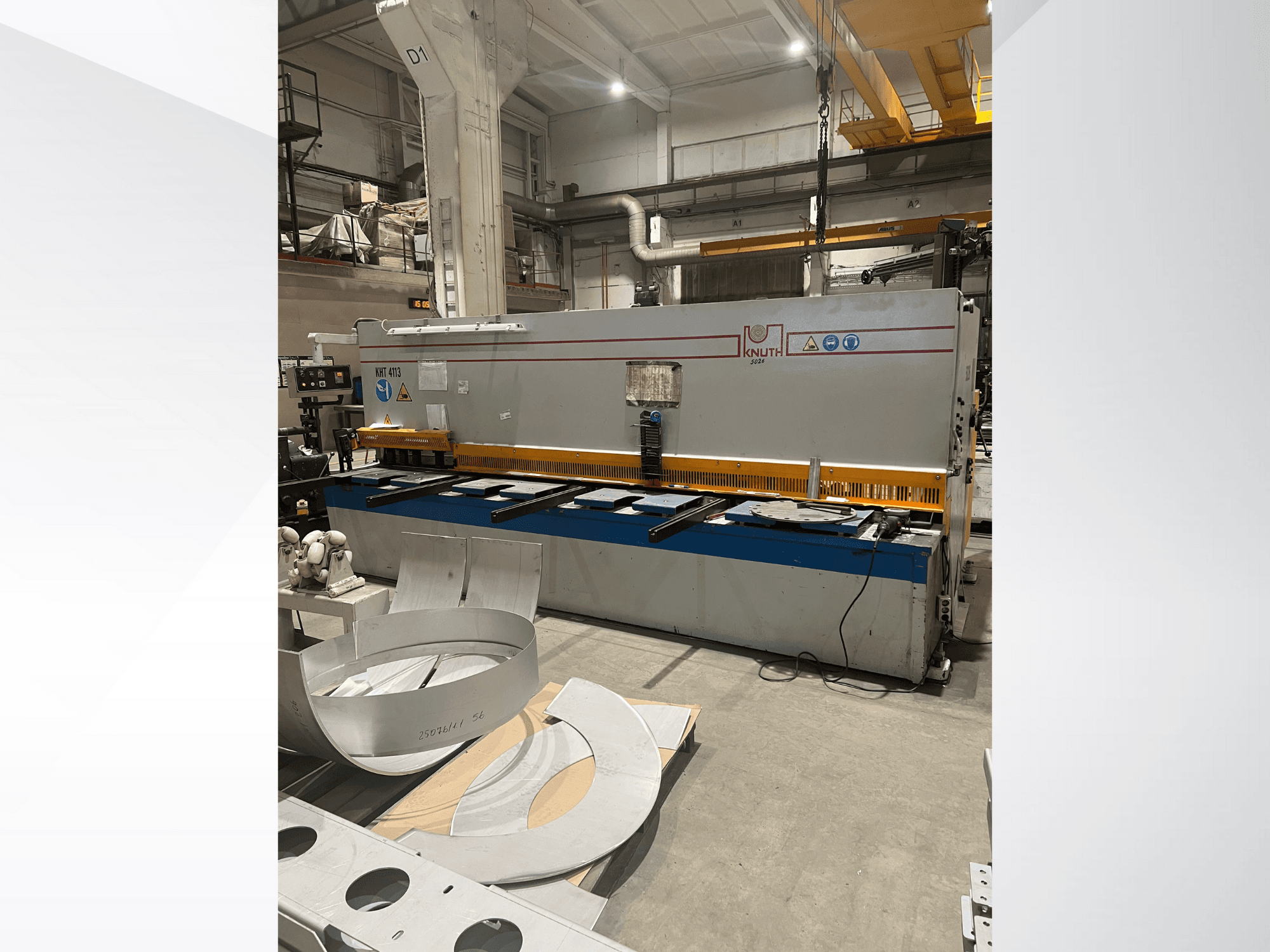 Машина для резки листового металла Knuth модели MT 4173 в мастерской, вид спереди на стол для резки и металлические листы.