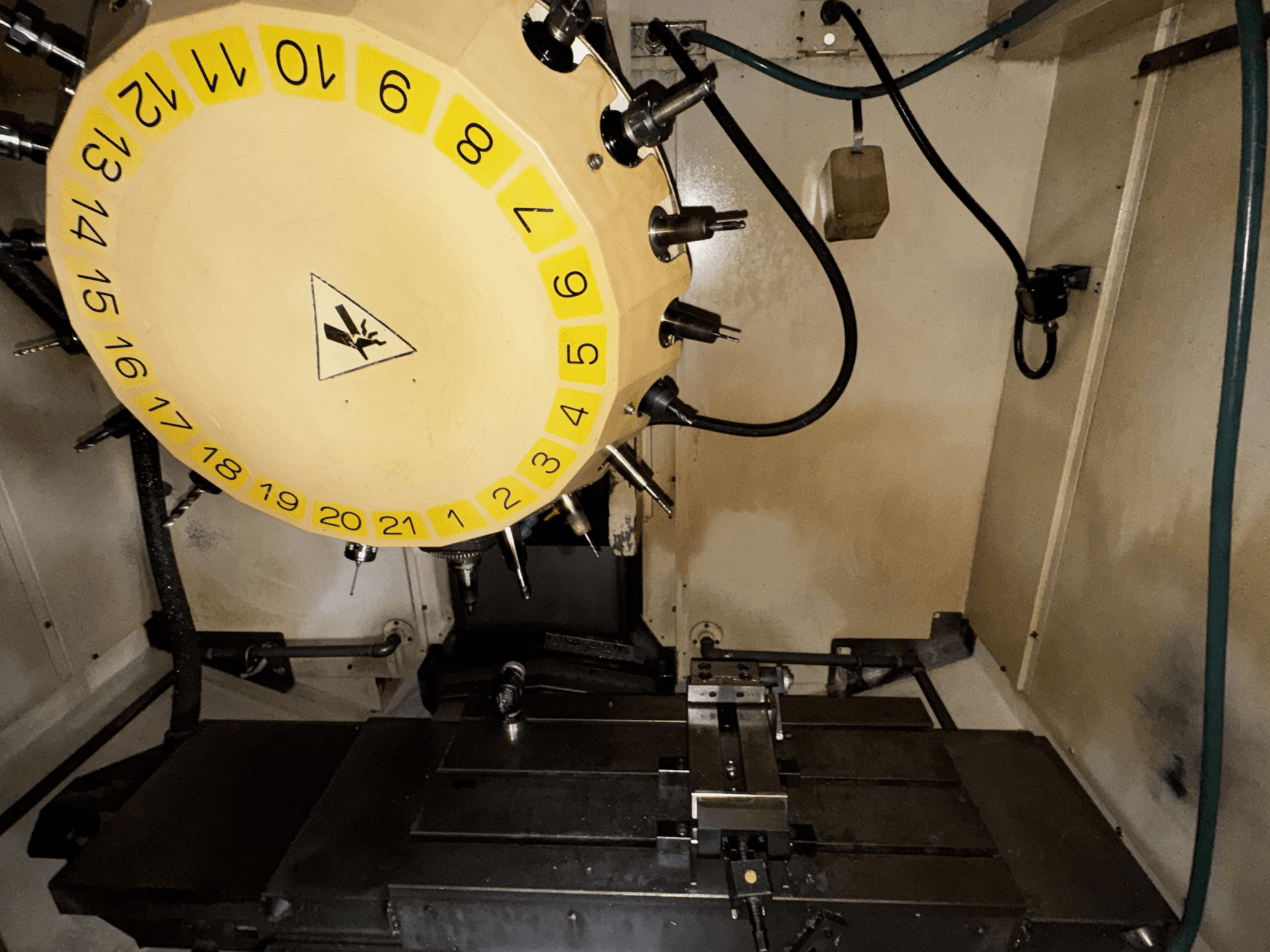 Вид изнутри вертикального обрабатывающего центра FANUC Robodrill alpha-T21iFL с каруселью инструментов и обрабатывающим столом.
