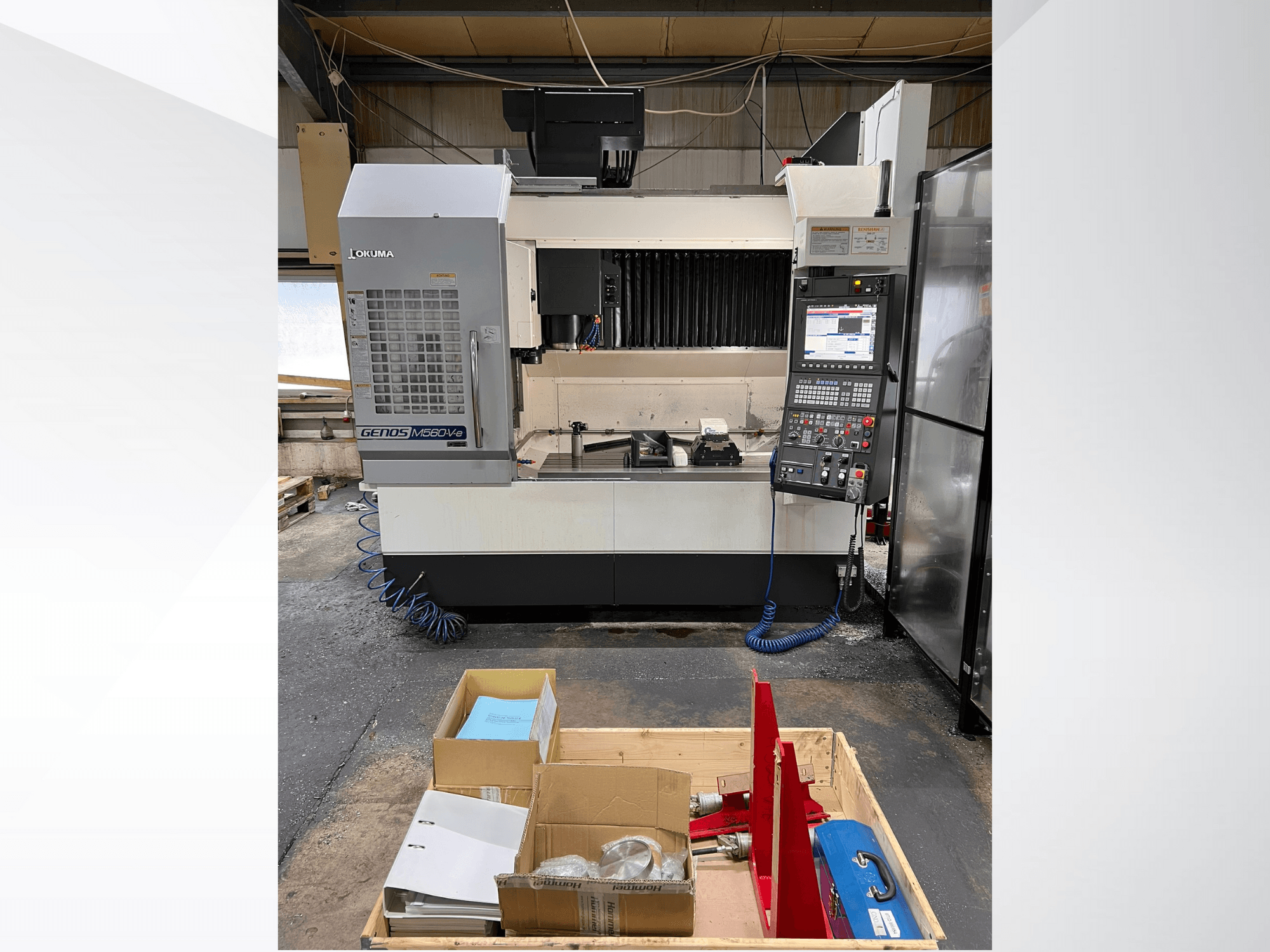 Вертикальный обрабатывающий центр Okuma GENOS M460V-5, вид спереди, видна панель управления, инструменты на рабочем столе.