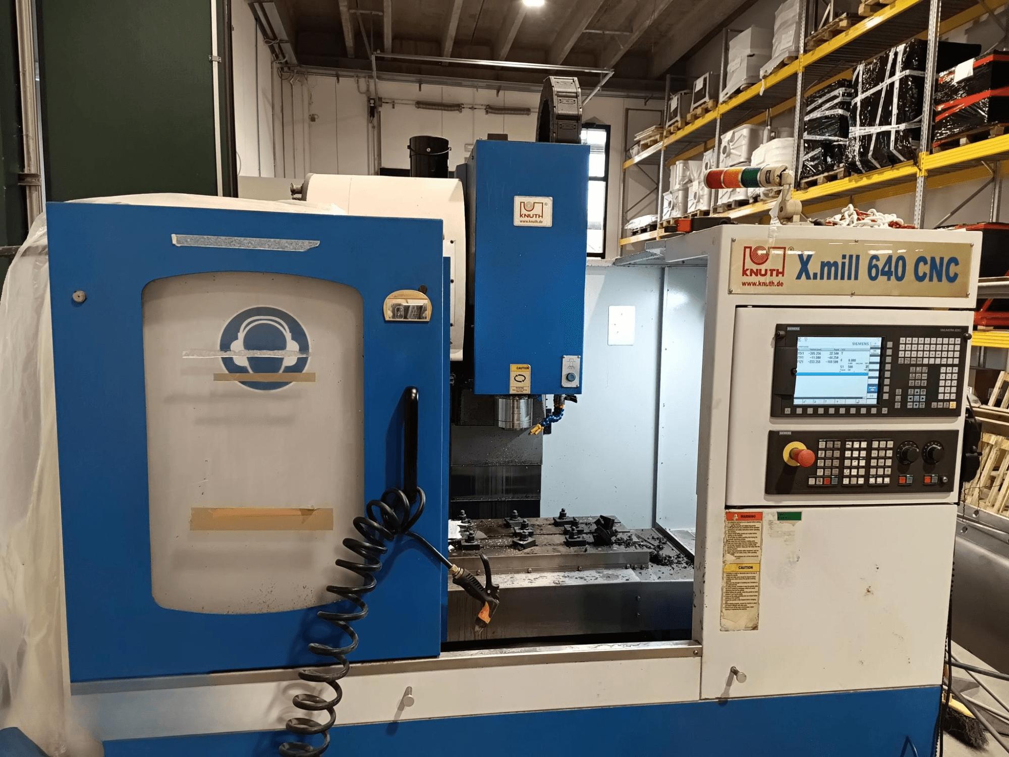 Станок с ЧПУ Knuth X.mill 640 с видом сбоку, с панелью управления, зоной шпинделя и видимой установкой заготовок.