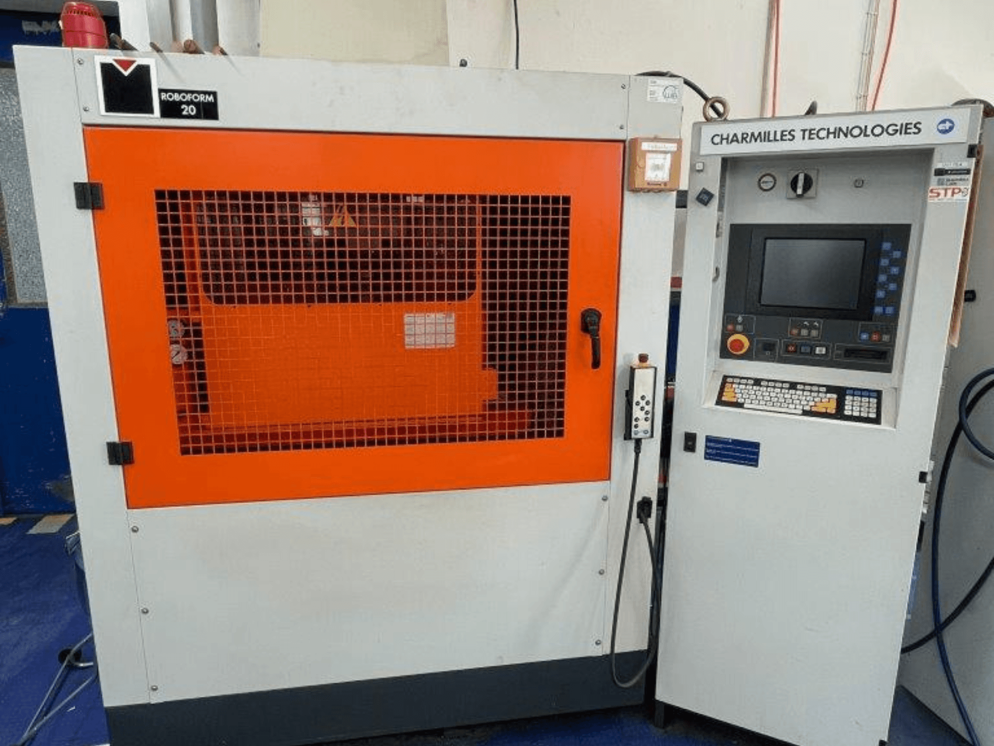 Станок для электроэрозионной обработки давлением AgieCharmilles Robofrom 20, вид спереди с панелью управления и оранжевой защитной решеткой.