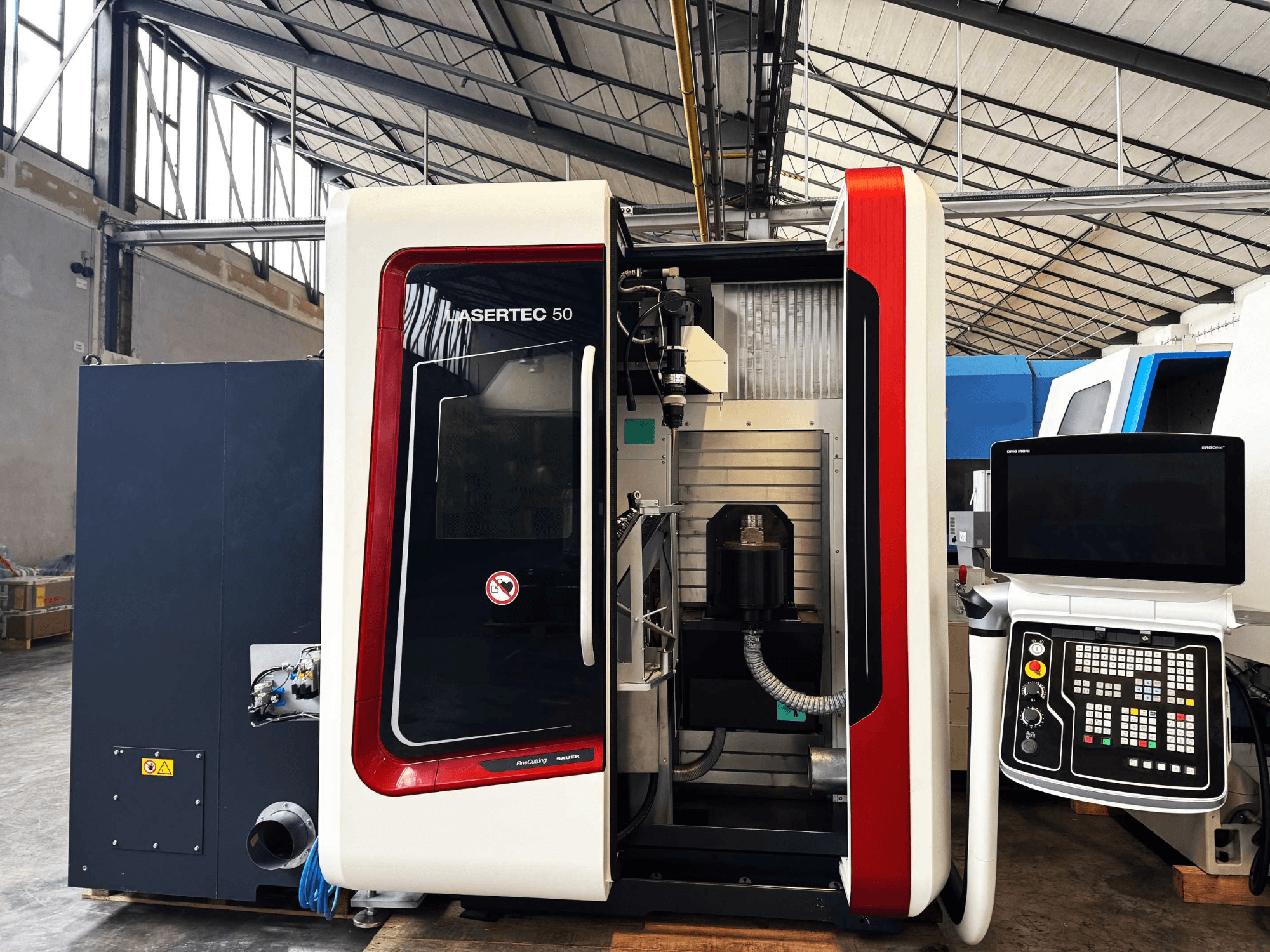 Станок с ЧПУ LaserTec 50 с видом сбоку, черно-белая панель управления, видимый держатель инструмента и промышленные настройки.