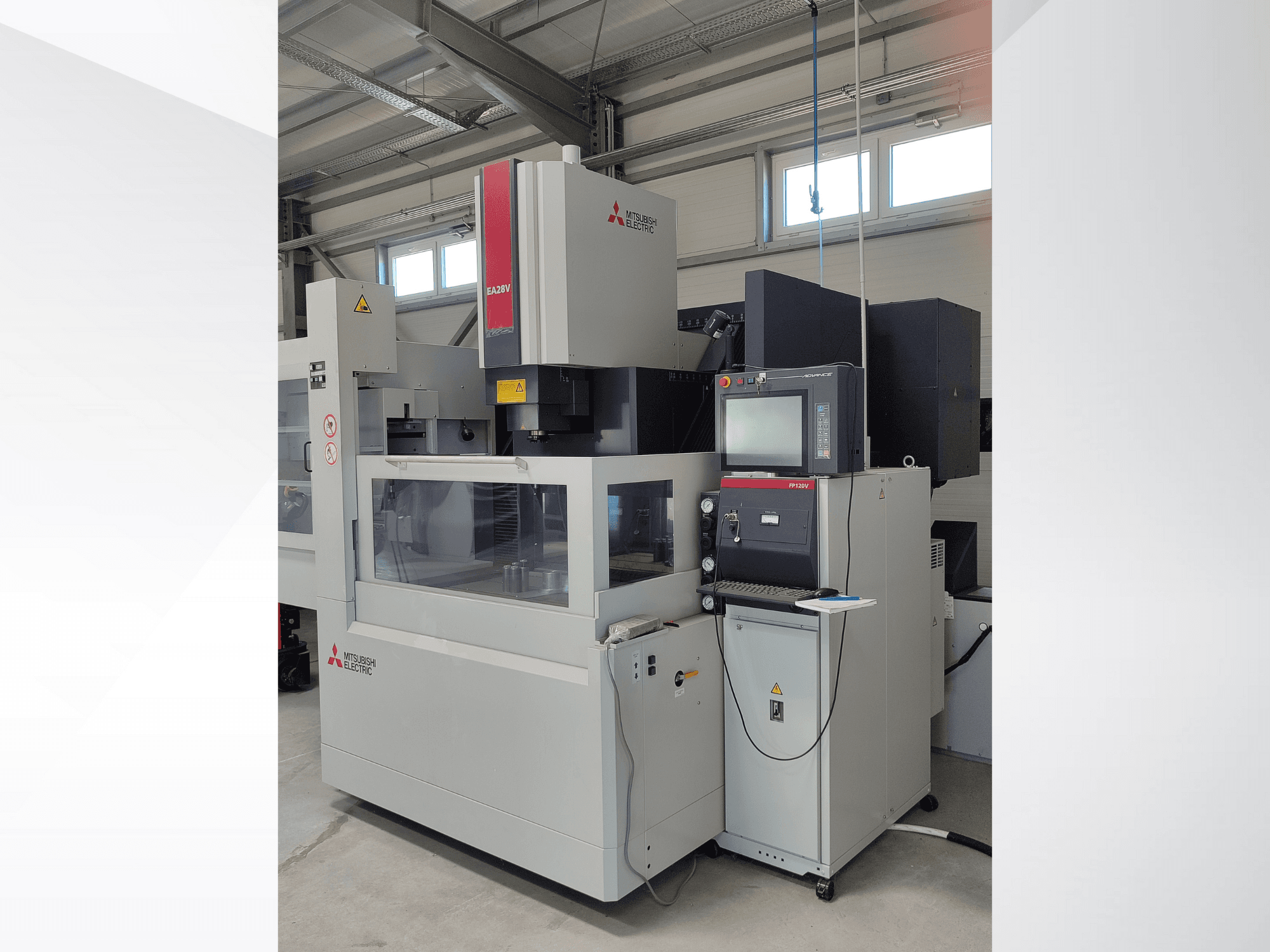 Проволочно-вырезной электроэрозионный станок Mitsubishi Electric EA32V с видом сбоку, с панелью управления и видимой через стекло рабочей зоной.