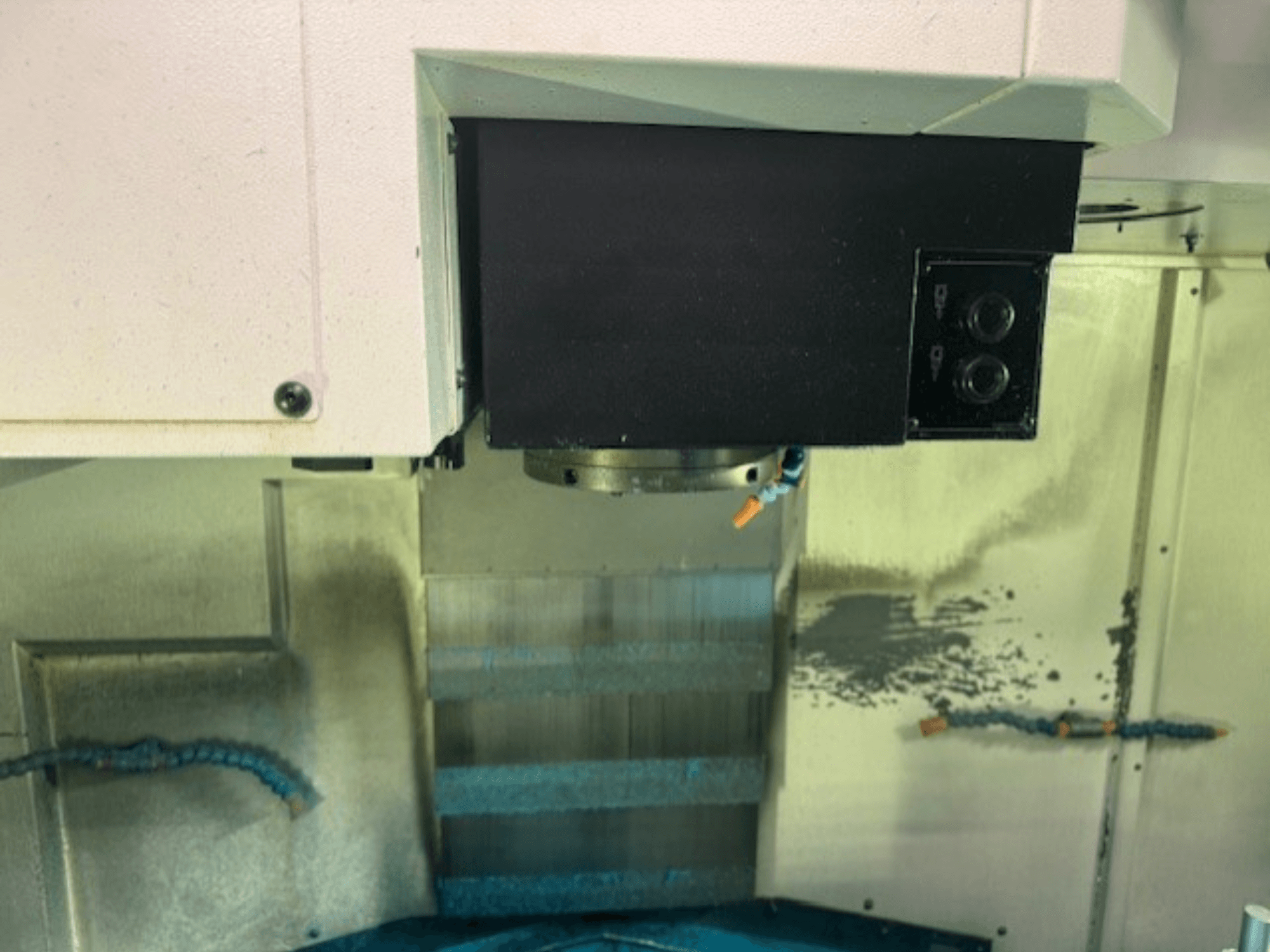 Крупный план панели управления фрезерного станка с ЧПУ и держателя инструментов, демонстрирующий фирменные детали, кнопки и рабочую поверхность.