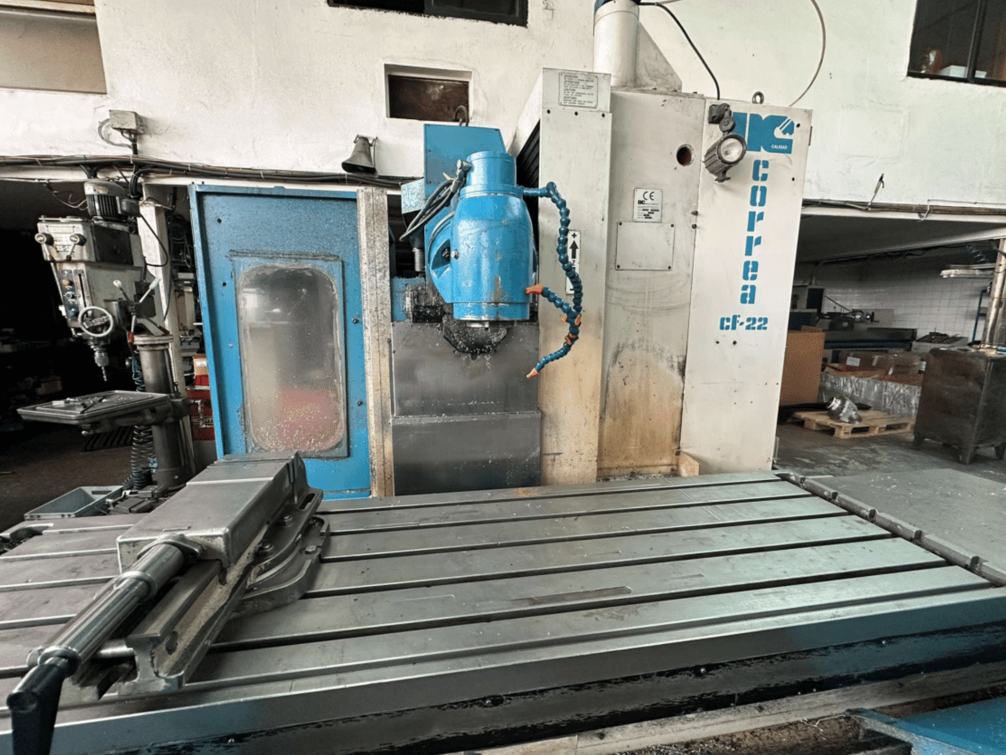 Фрезерный станок Correa CF-22 с видом спереди, в сине-серебристом дизайне, с подвижным столом и режущей головкой.