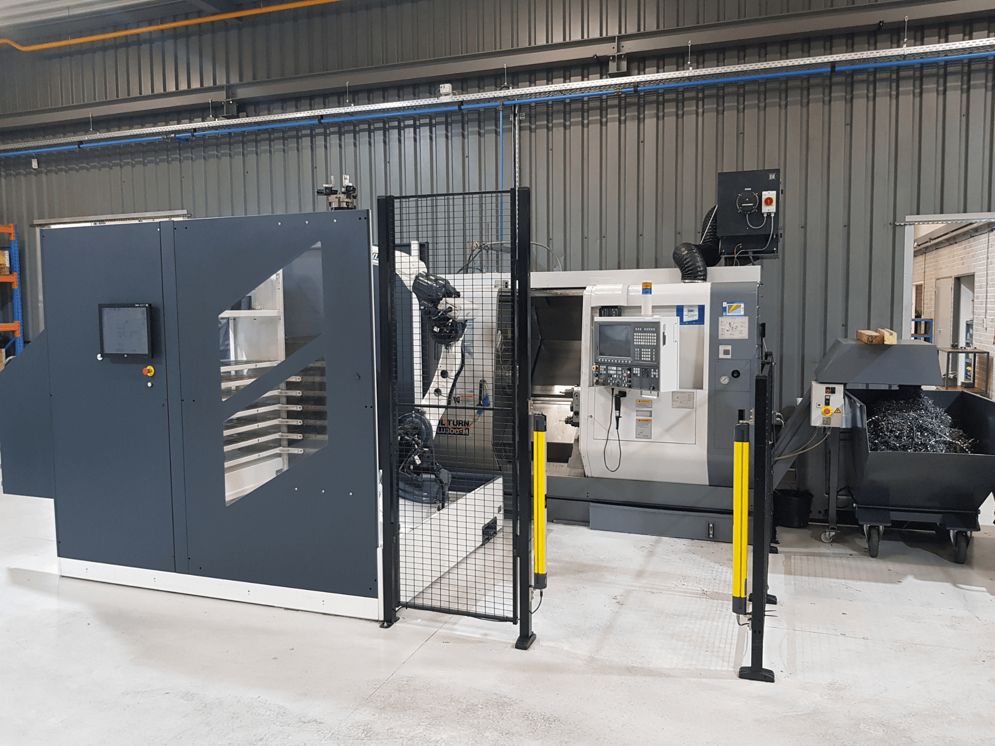 Автоматизированный токарный станок с ЧПУ ALTURN в заводских условиях; вид спереди, видны панель управления и защитные ограждения.