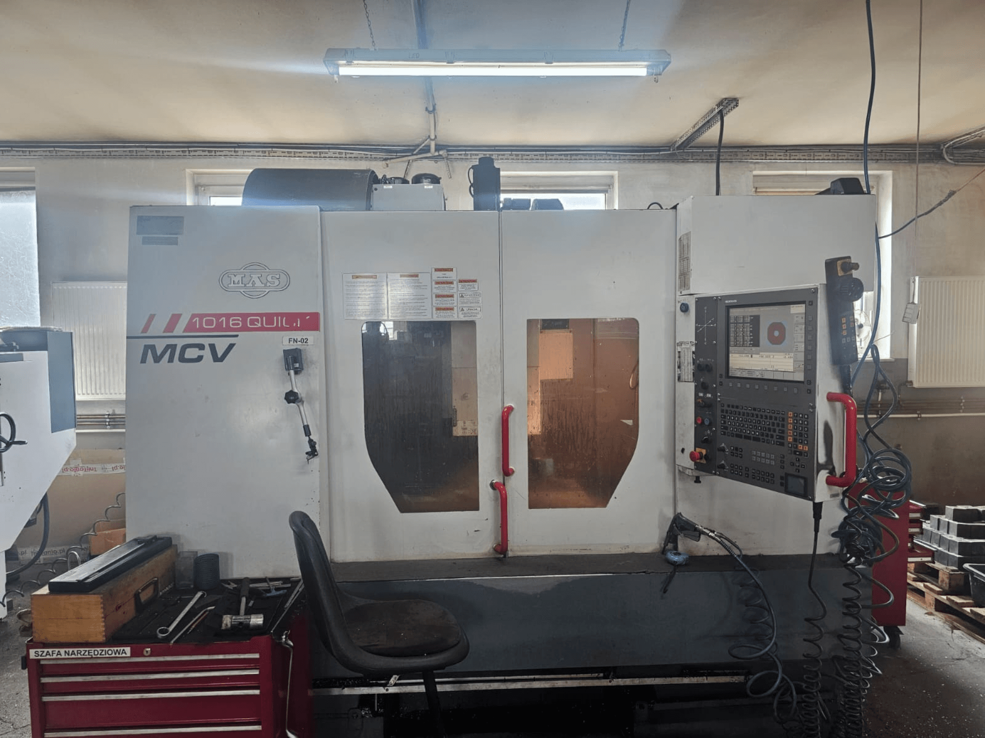 Станок с ЧПУ MVS MCV 1016 QUILL, вид спереди, панель управления, ящик для инструментов и рабочее место с инструментами.