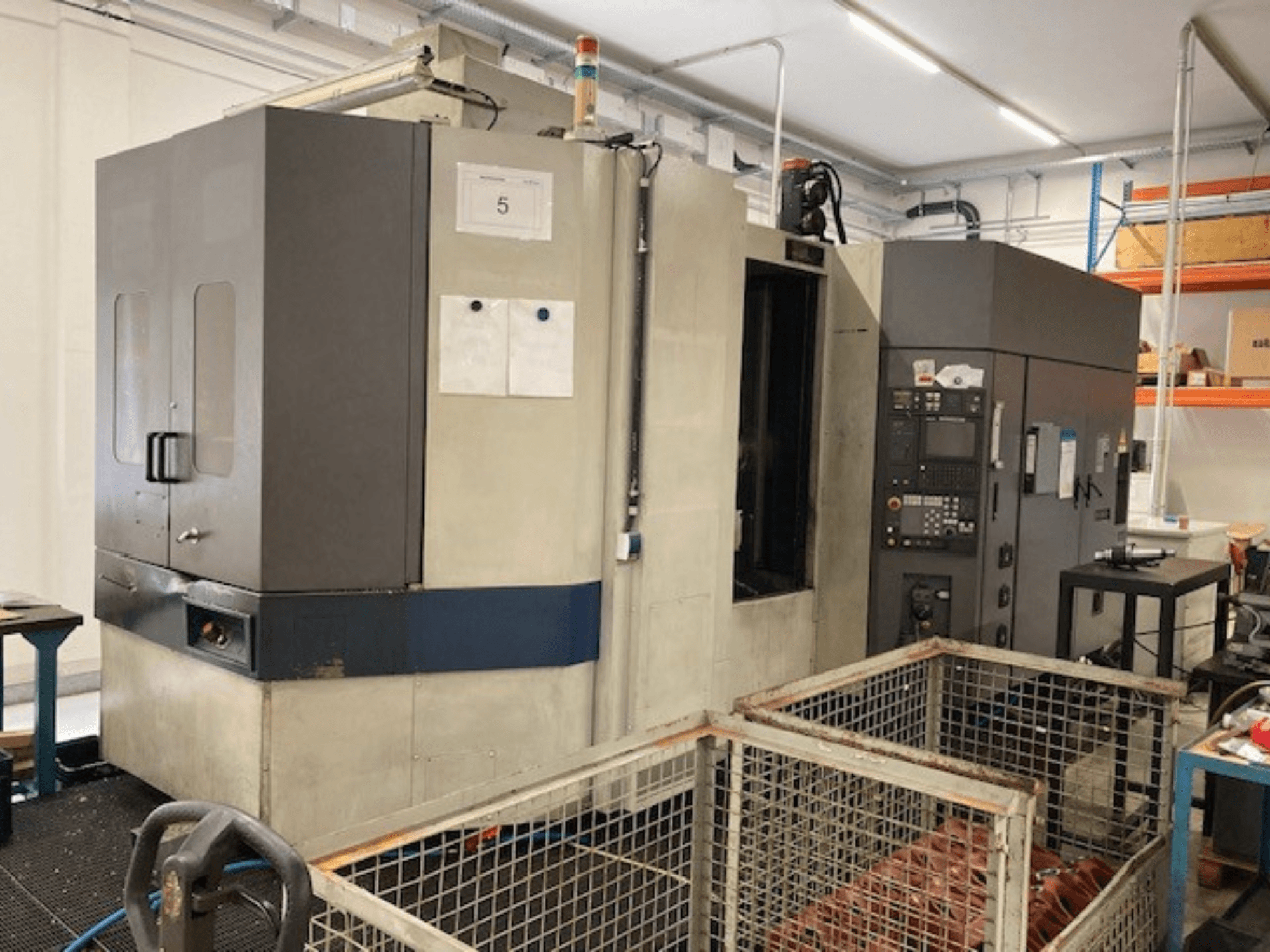 Горизонтальный обрабатывающий центр MORI SEIKI SH633, вид спереди, демонстрирует панель управления и функции безопасности.