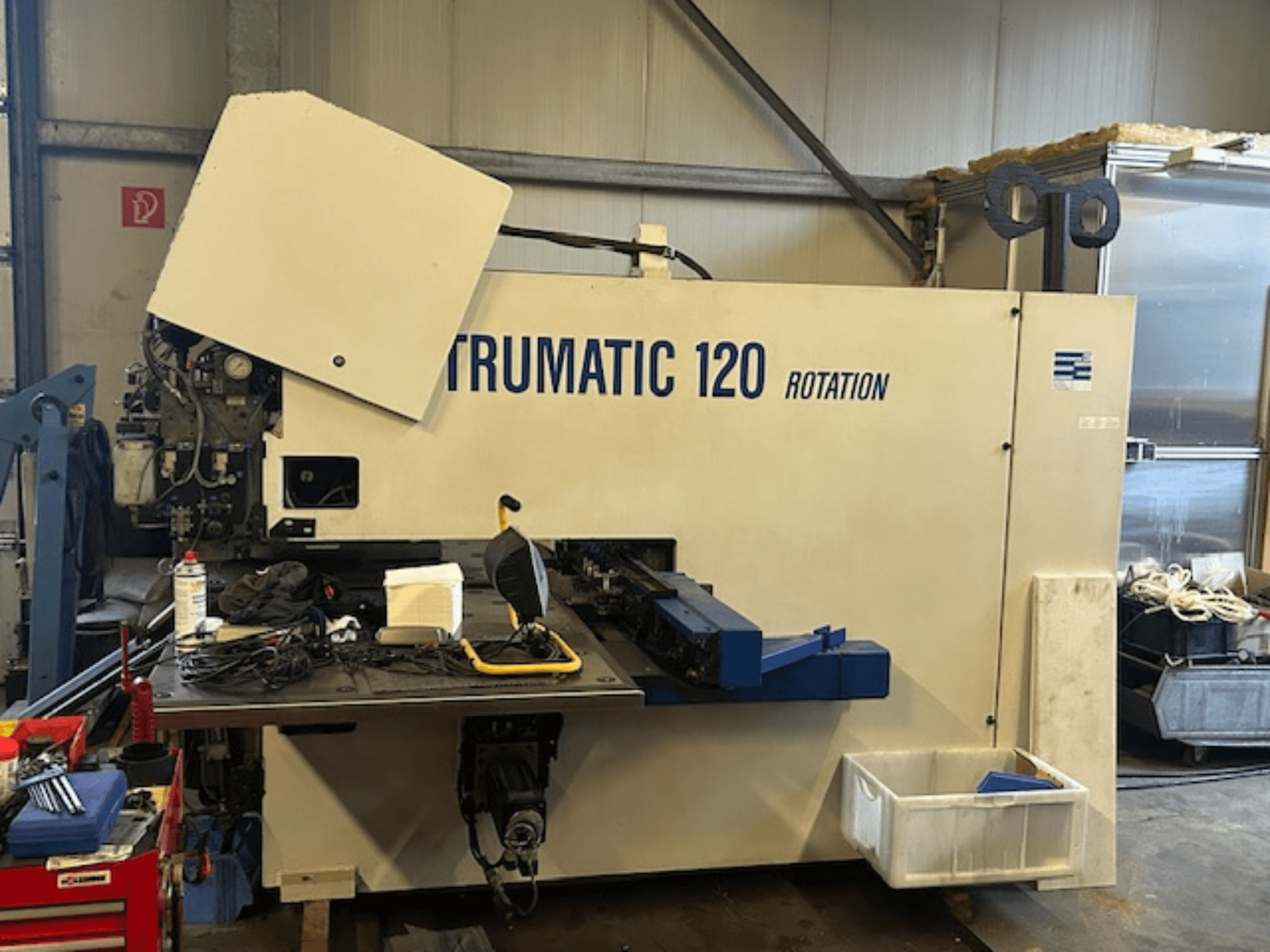 Пробивной станок с ЧПУ TRUMPF Trumatic 120R в мастерской, вид спереди, панель управления и инструменты на столе.