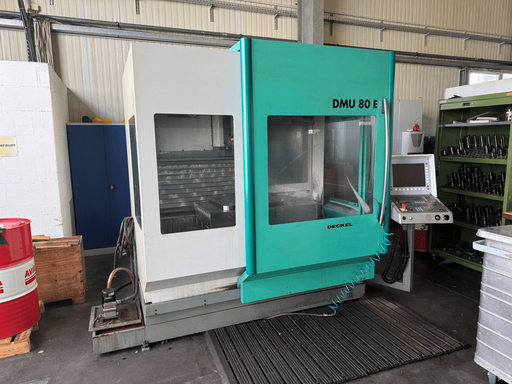 Вид спереди вертикального обрабатывающего центра DECKEL DMU 80 E с панелью управления и рабочей зоной.