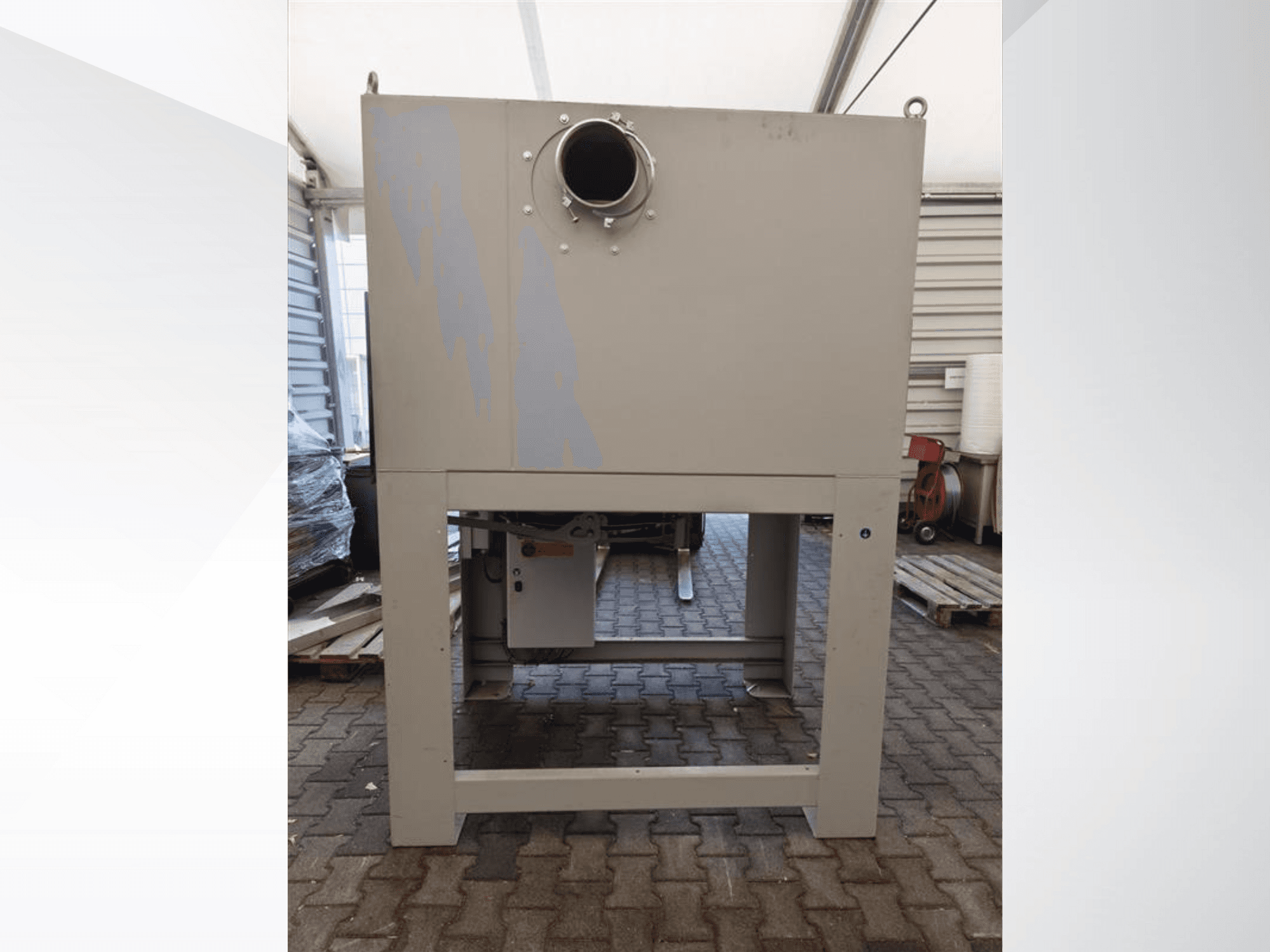 Серый промышленный пылесборник спереди, с большим круглым отверстием и на прочном основании.