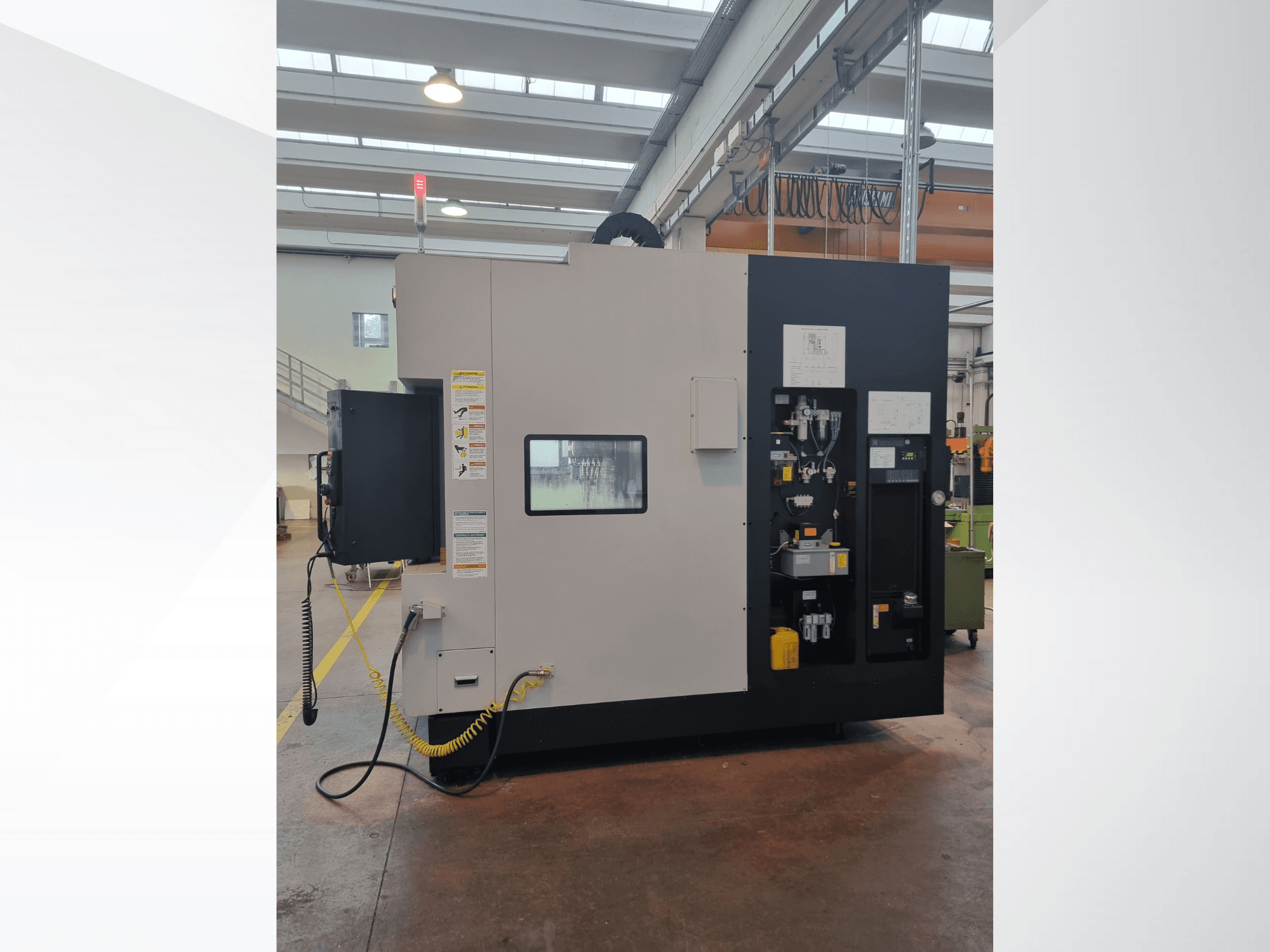 Промышленная машина с видом сбоку, имеет панель управления с кнопками, индикаторами и табличкой с предупреждением о безопасности.