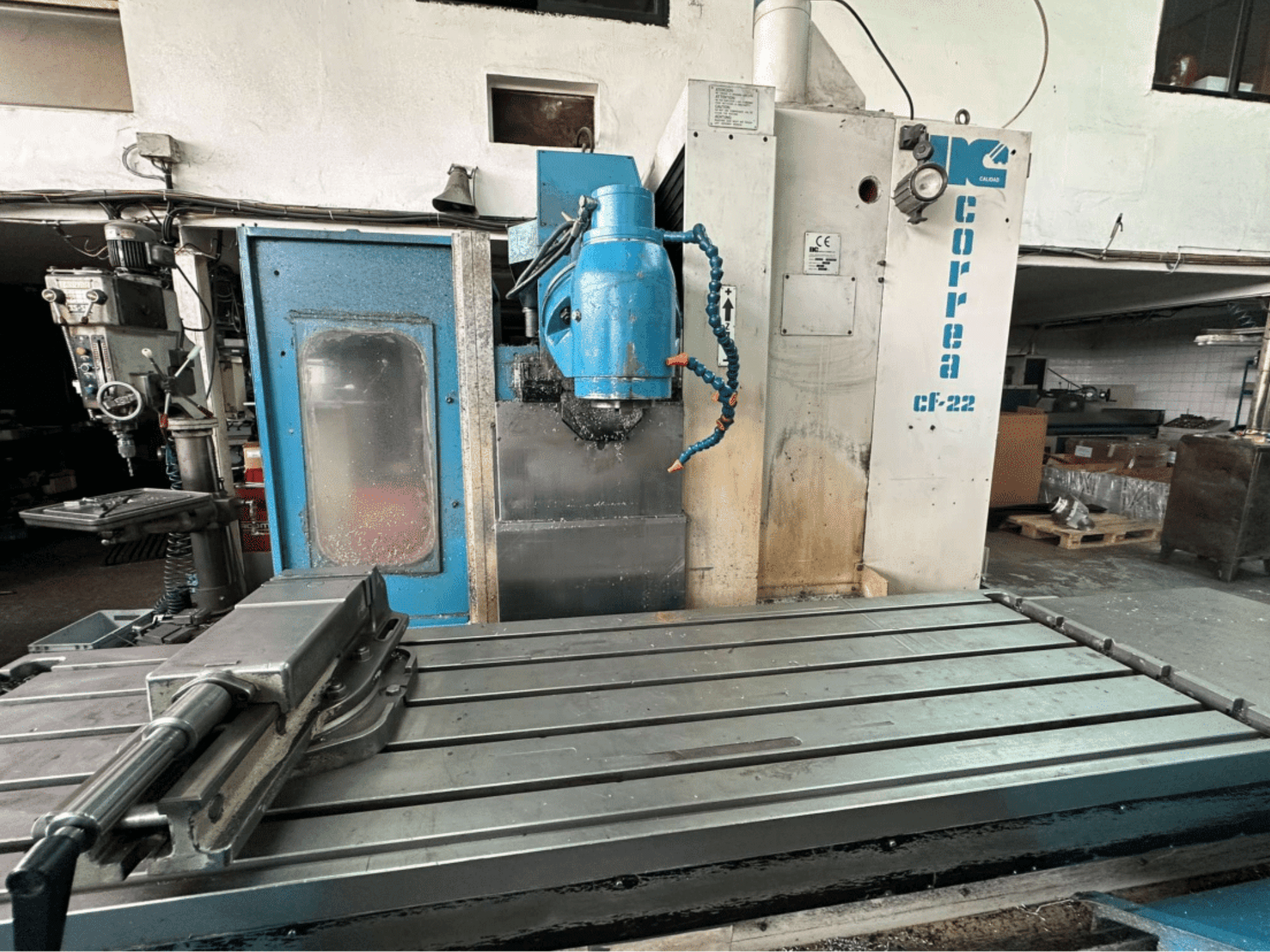 Фрезерный станок Correa CF-22, вид спереди; металлический рабочий стол и сине-белая панель управления с ручками.